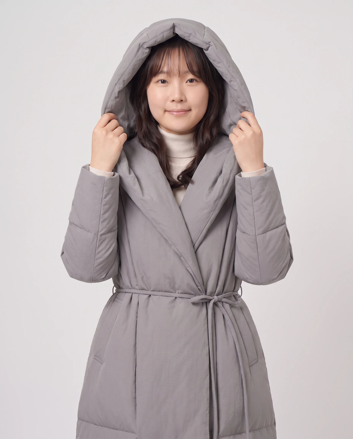 Doudoune longue portefeuille à capuche oversize Aurélia en Gris, plan rapproché, col châle et ceinture nouée
