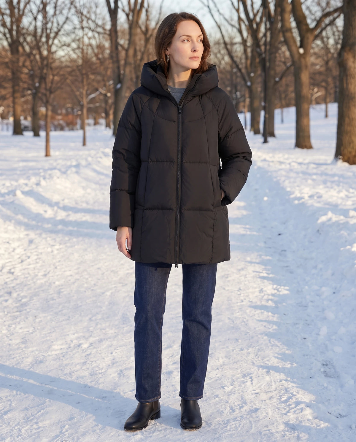 Doudoune mi-longue noire Marianne portée fermée dans une allée de parc enneigée