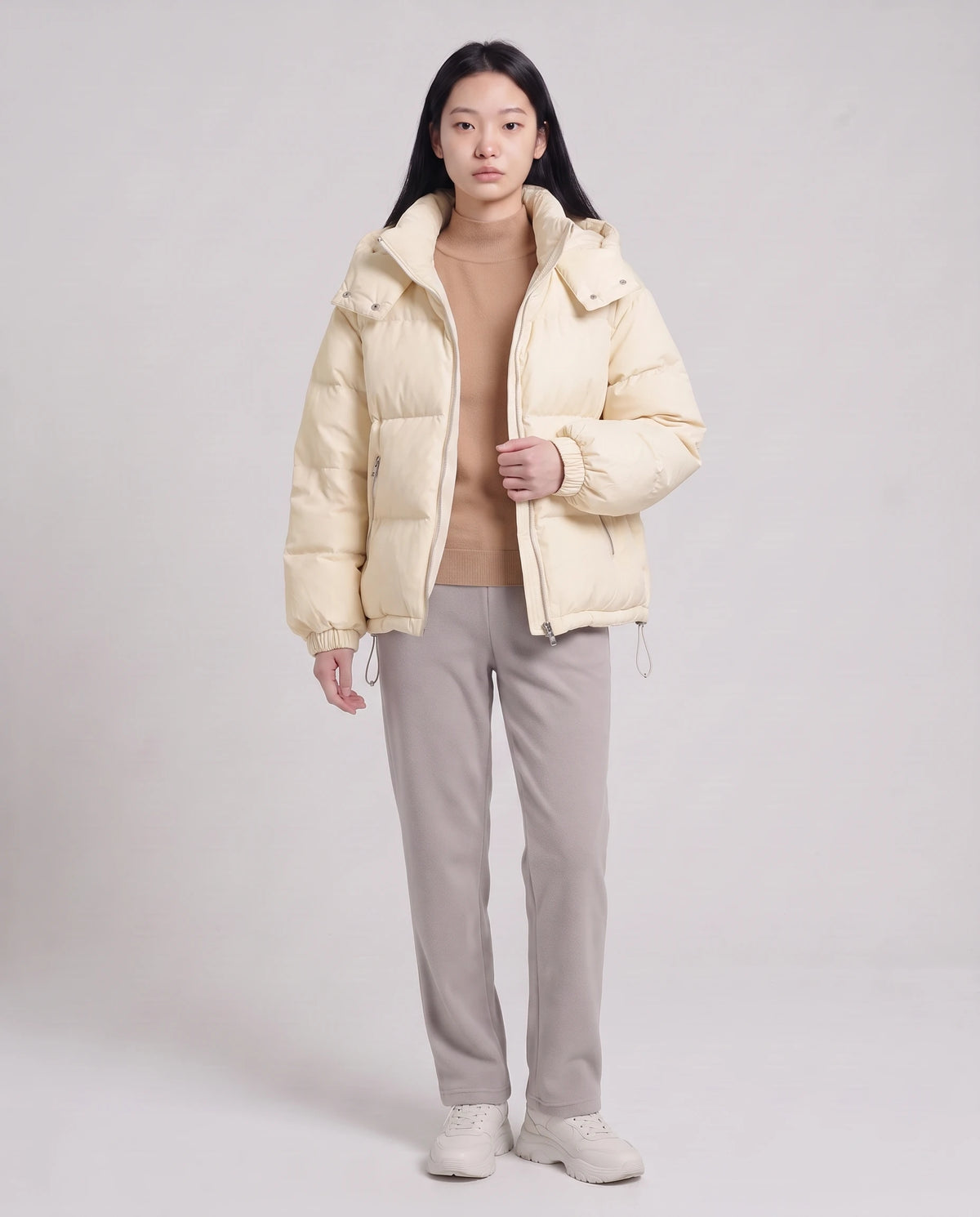 Doudoune courte oversize à capuche amovible Camélia, coloris Blanc Cassé, portée ouverte sur un pull camel