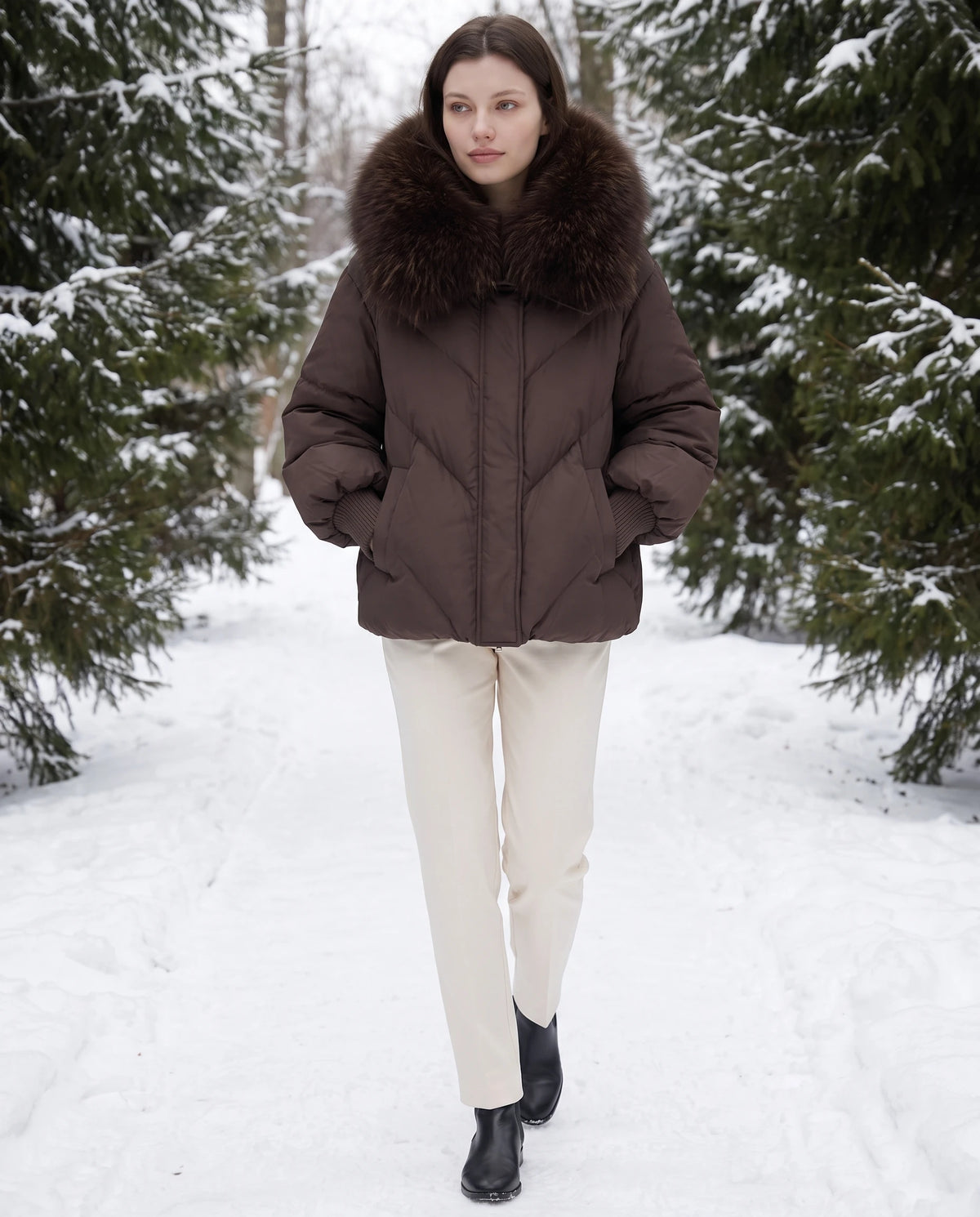 Doudoune oversize à col châle fausse fourrure Sabrina en Chocolat, portée sur un chemin forestier enneigé, col relevé