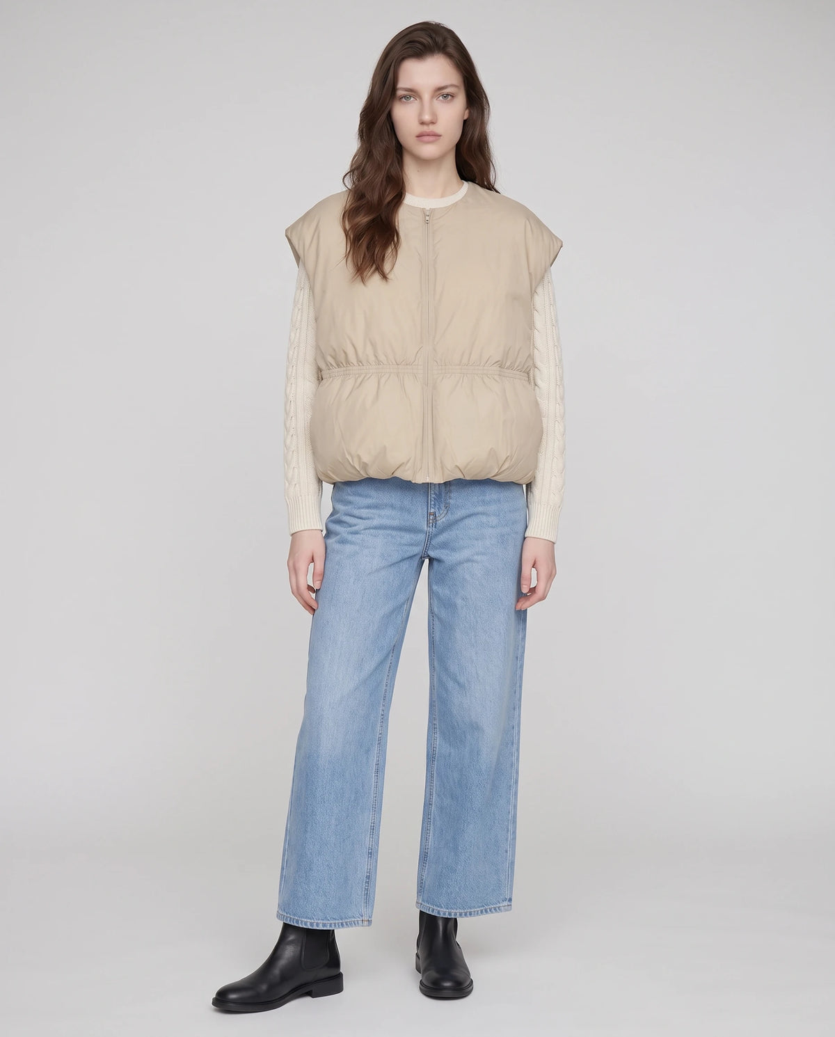Ärmellose Steppweste im Cocon-Schnitt Béatrix in Naturleinen, Ganzkörperansicht über cremefarbenem Strickpullover und weiter Jeans