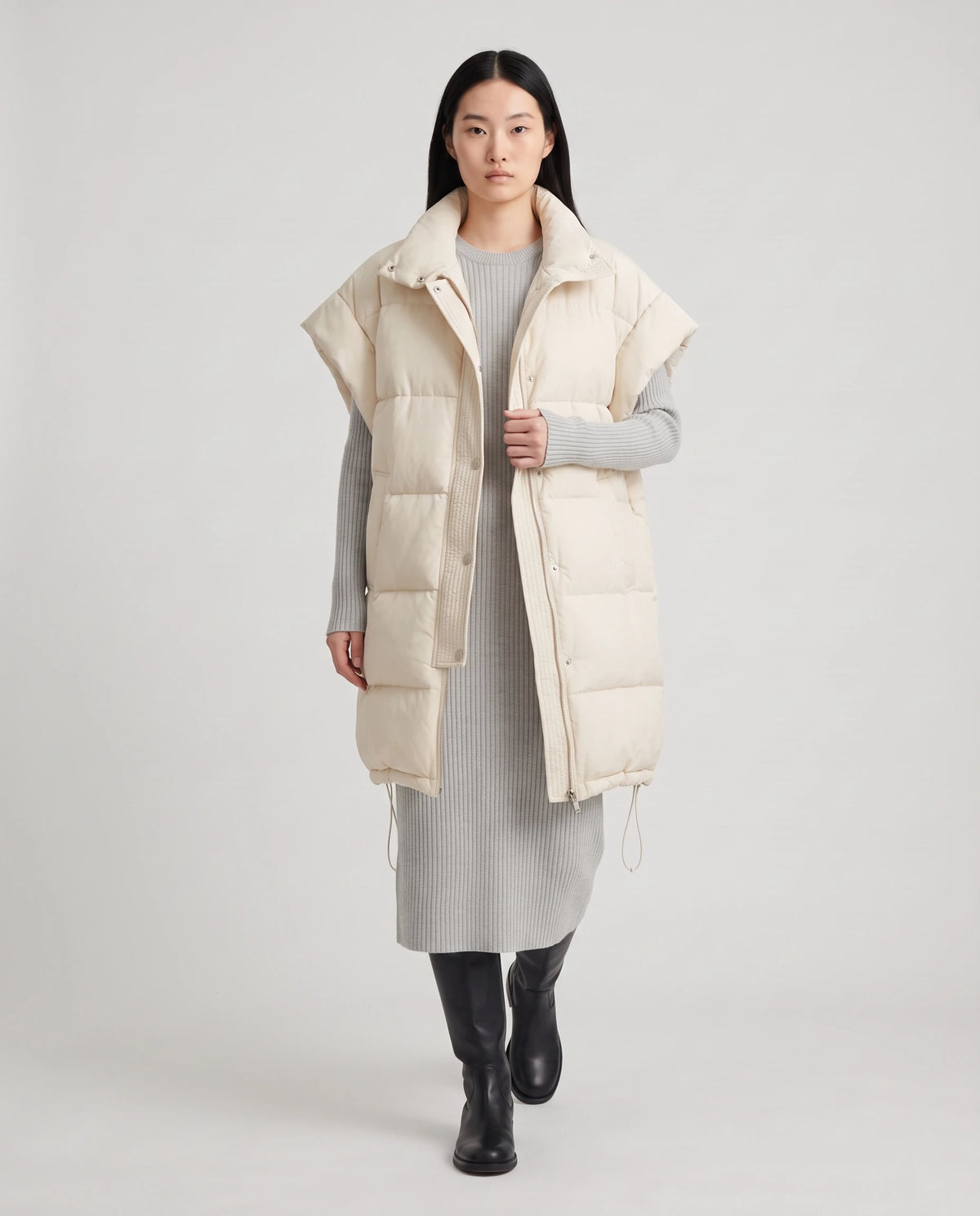 Doudoune sans manches oversize à grand col et patte plissée Perline en Écru, portée ouverte sur une robe-pull en maille gris perle