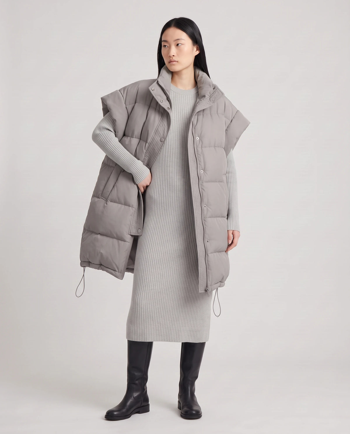 Doudoune sans manches oversize à grand col et patte plissée Perline en Gris, portée ouverte sur une robe-pull gris perle, vue en pied