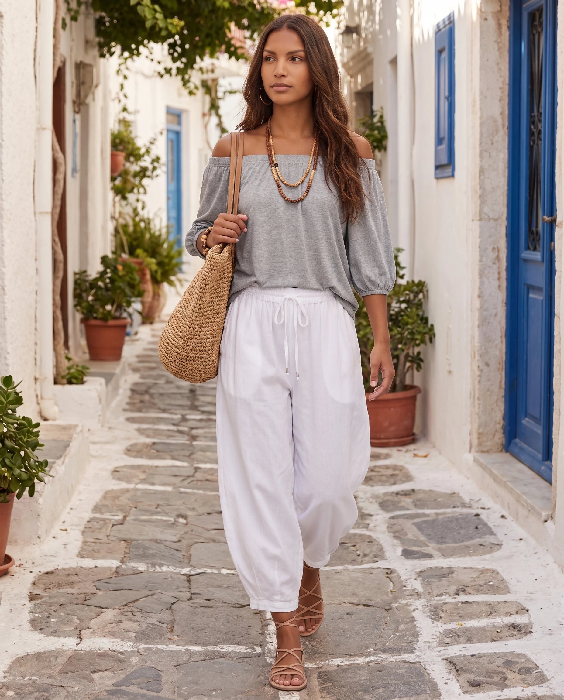 Ensemble epaules denudees et pantalon sarouel Gris portee dans une ruelle blanche de village - Lorene | Zolena