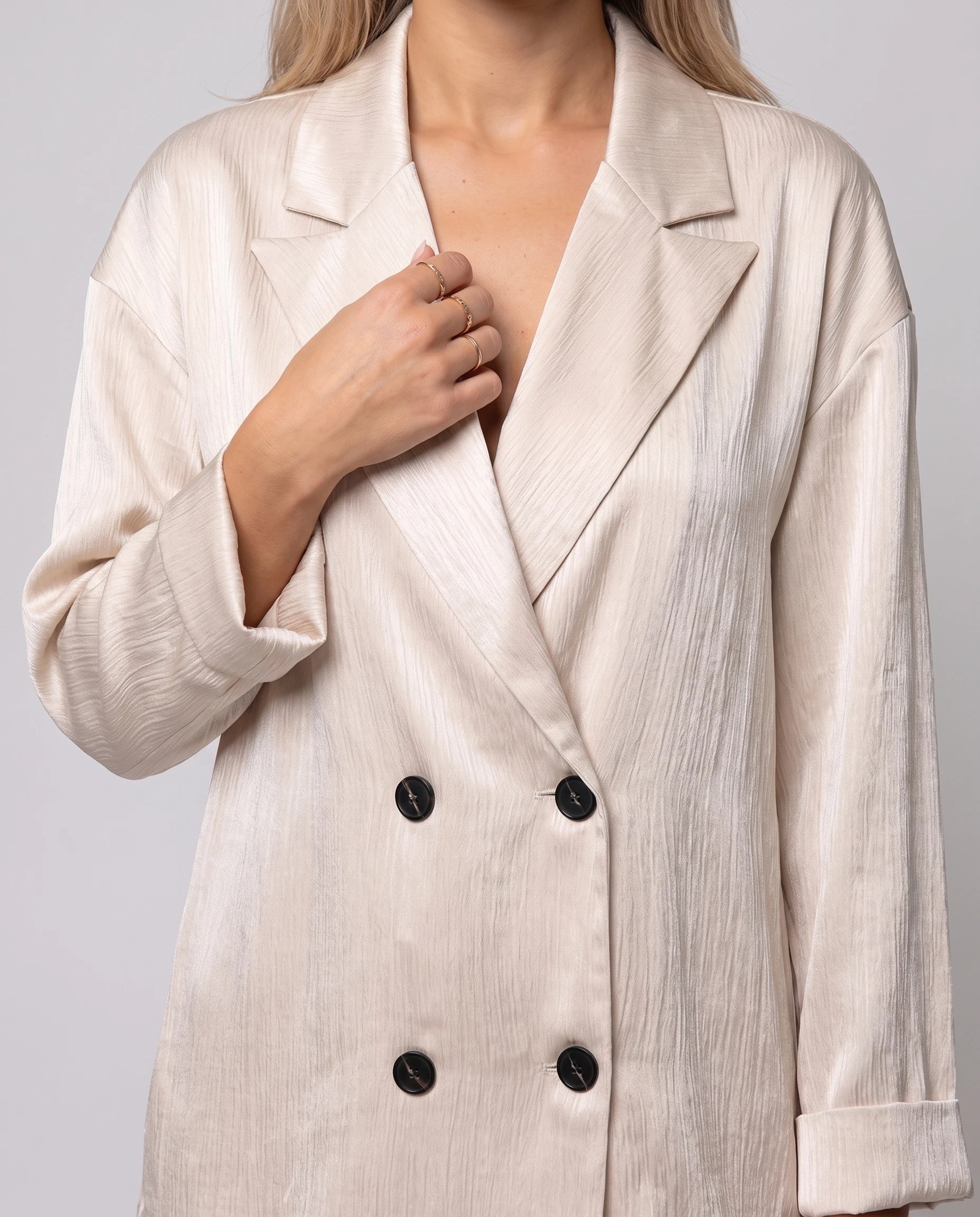 Détail du blazer croisé à double boutonnage en satin froissé beige