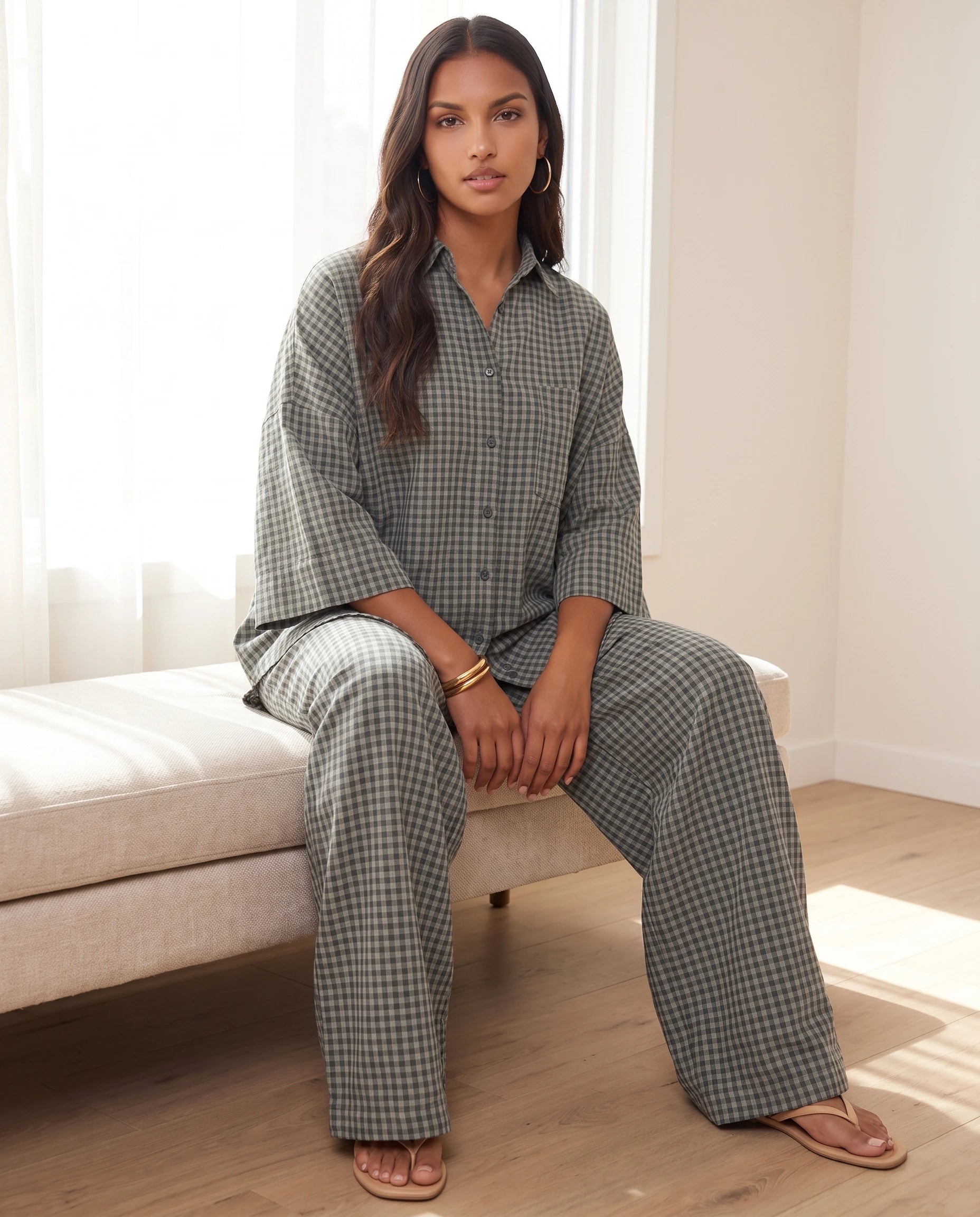 Ensemble chemise oversize et pantalon a carreaux Gris Vert assise dans une pièce lumineuse - Cyrielle | Zolena