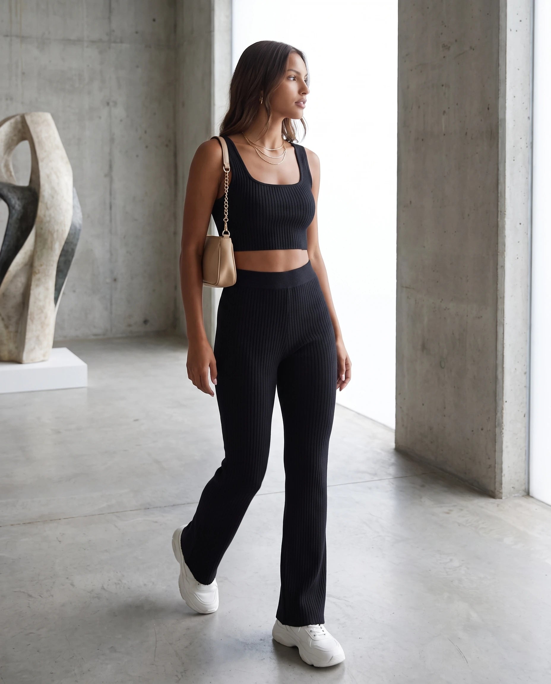 Ensemble top court et pantalon en maille cotelee Noir portee dans une galerie d art en beton - Elvire | Zolena