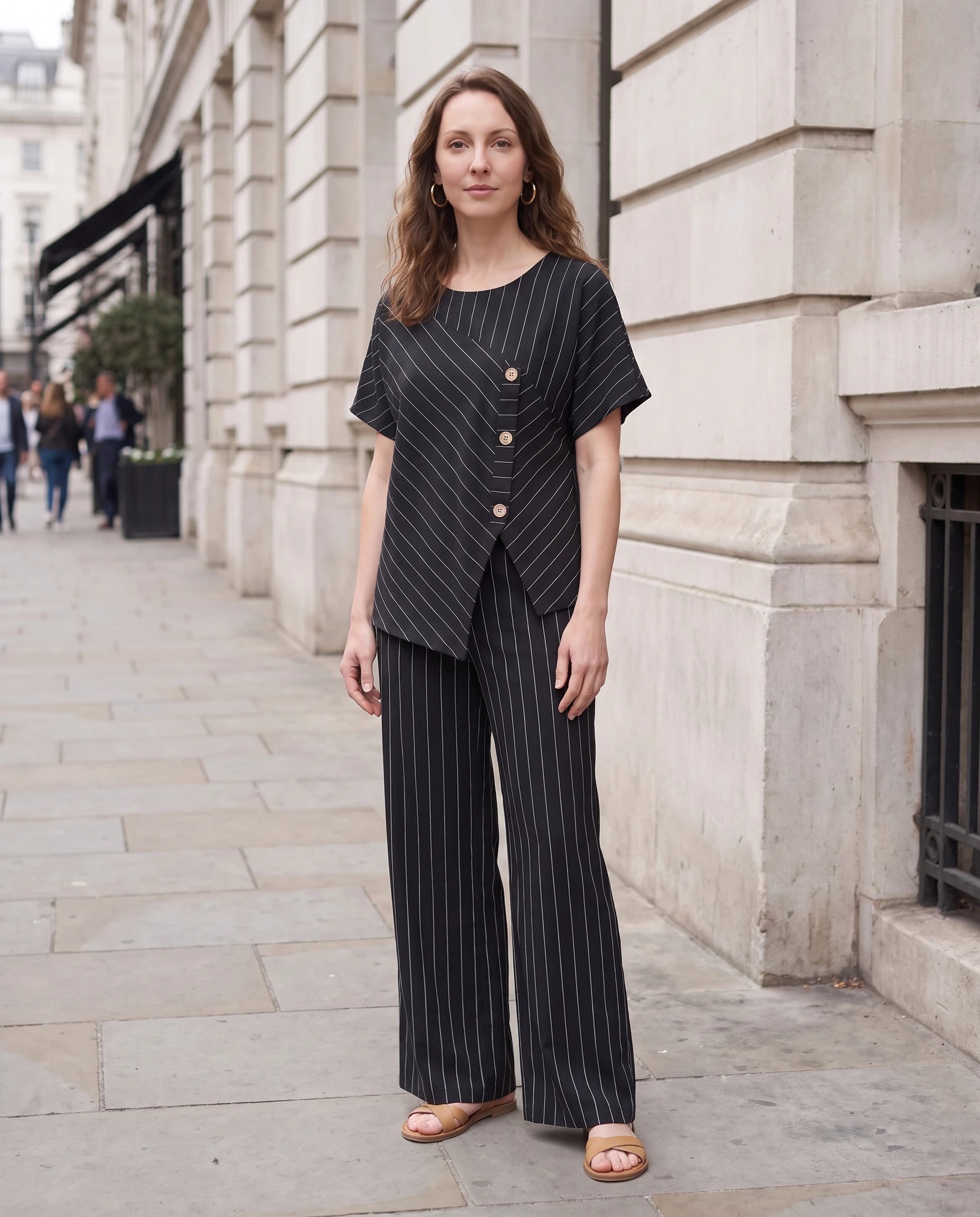 Ensemble top raye asymetrique et pantalon large Noir porté dans une rue élégante - Amandine | Zolena
