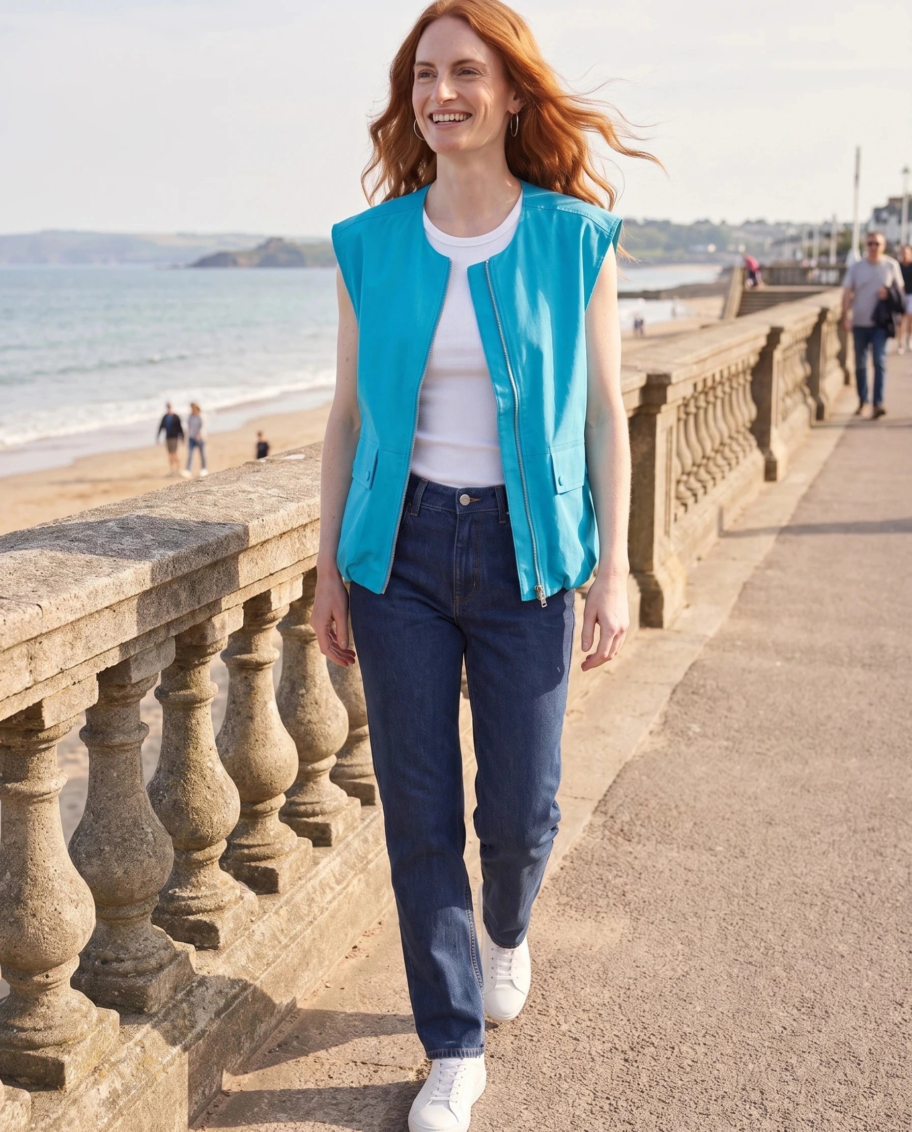 Gilet cargo zippé bleu turquoise Donatienne, porté sur une promenade en front de mer