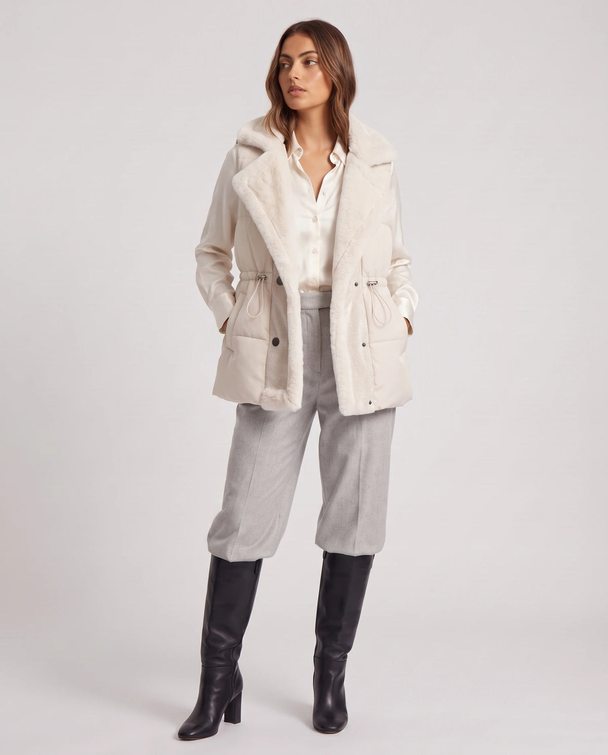 Gilet sans manches à col fausse fourrure Zélia Blanc Cassé, porté ouvert sur un chemisier ivoire, doublure fausse fourrure visible