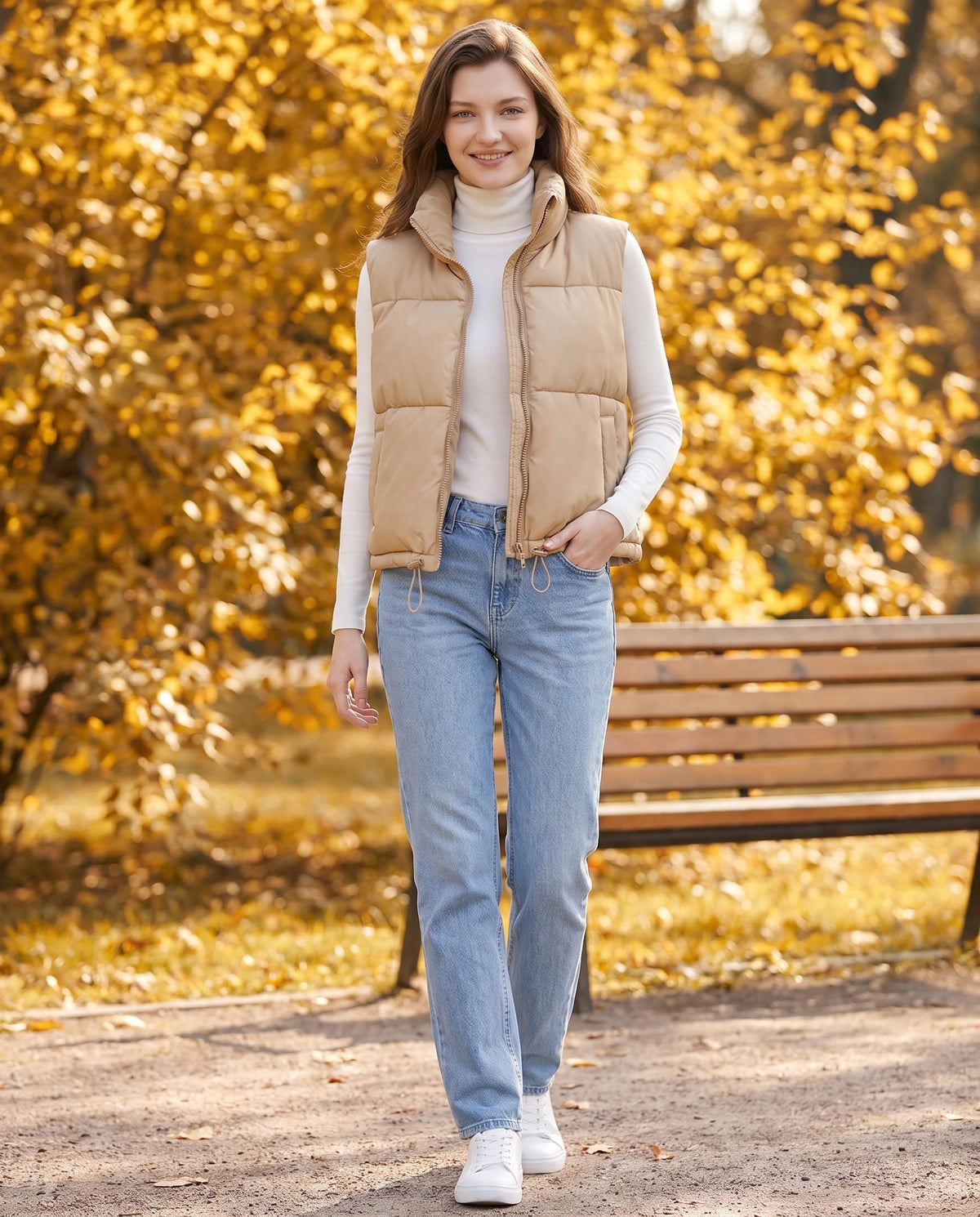 Gilet matelassé cropped à col montant et ourlet à cordon Lydie en Beige, portée dans un parc en automne près d'un banc