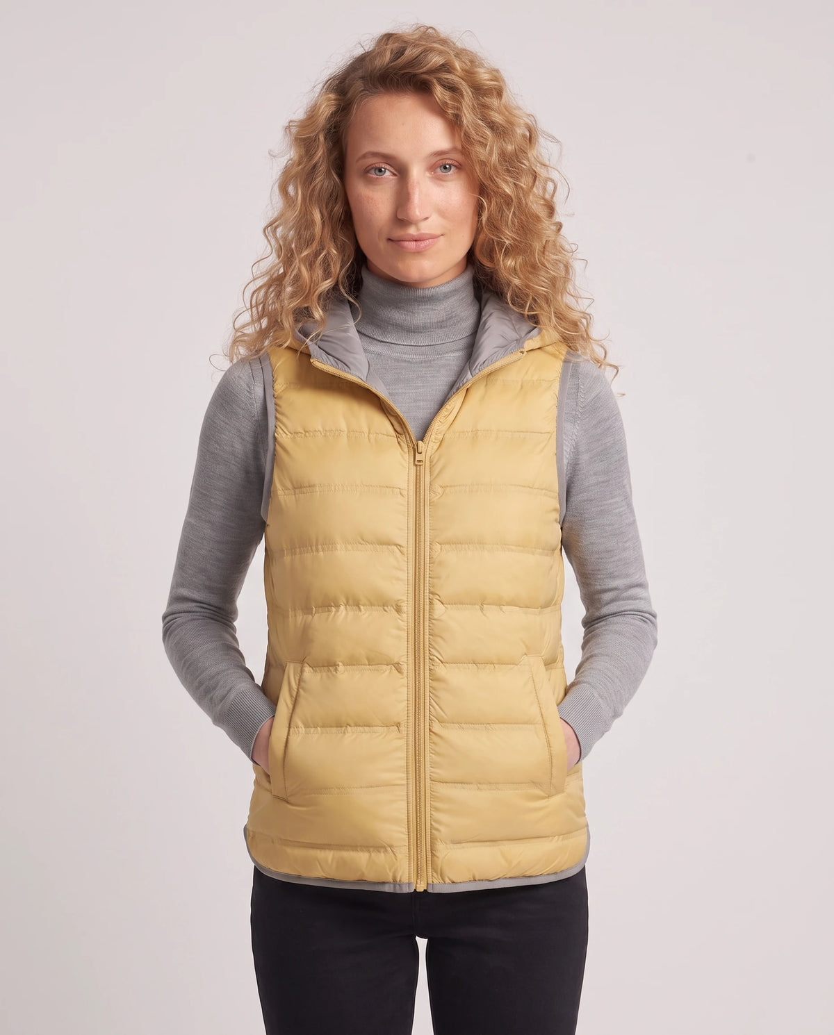 Gilet matelassé léger à capuche et doublure contrastée Laurence en Jaune, plan rapproché, zippé au menton, capuche baissée