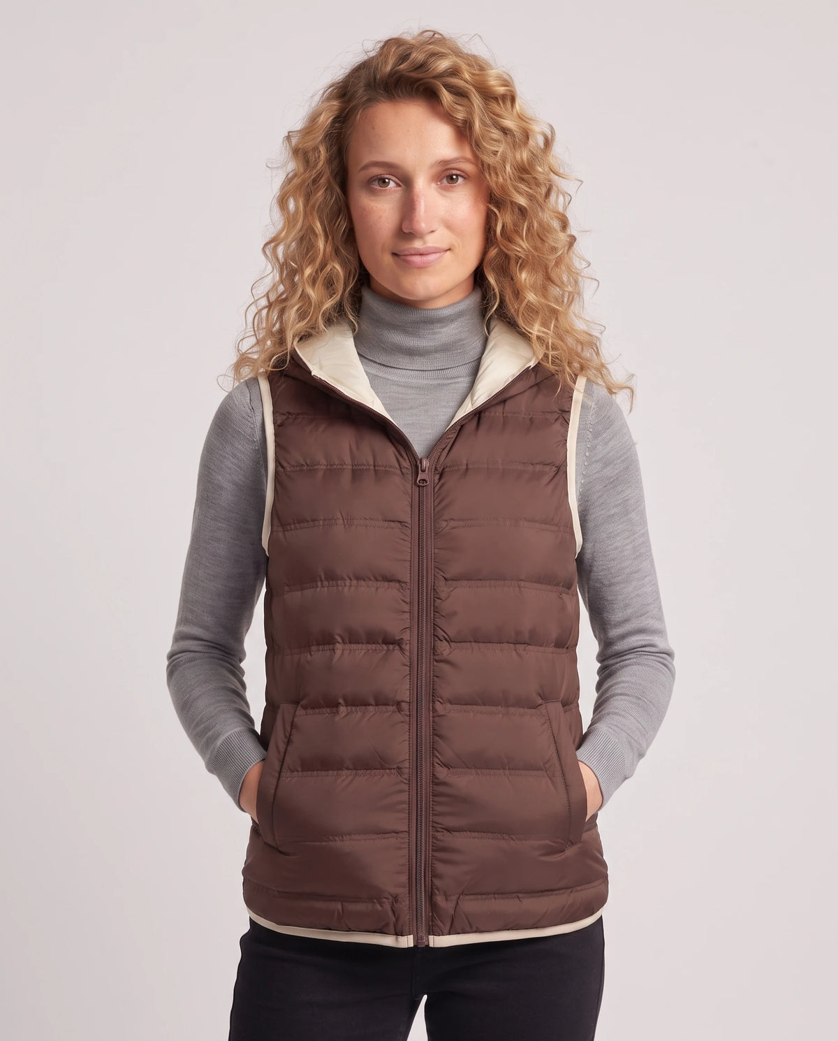 Gilet matelassé léger à capuche et doublure contrastée Laurence en Marron, plan rapproché, zippé au menton, capuche baissée