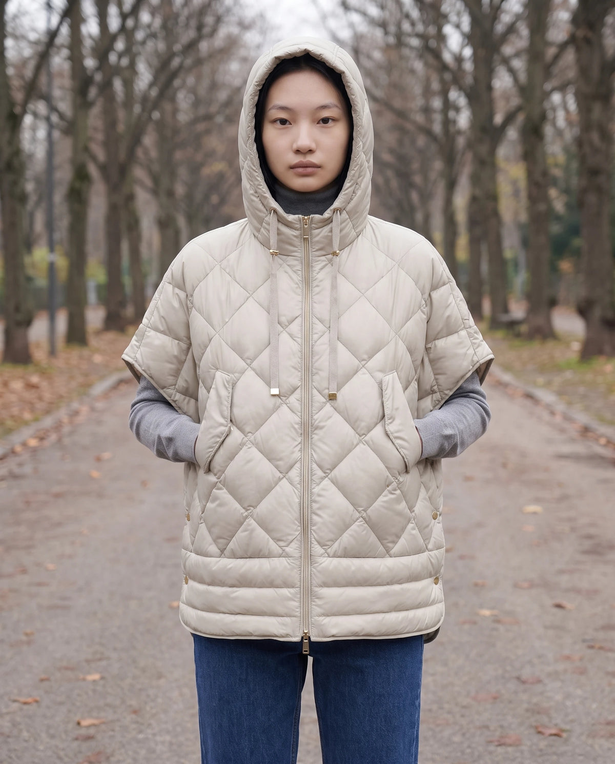 Gilet matelassé à capuche et pressions Céline en Beige, portée sur une avenue bordée d'arbres nus, capuche relevée
