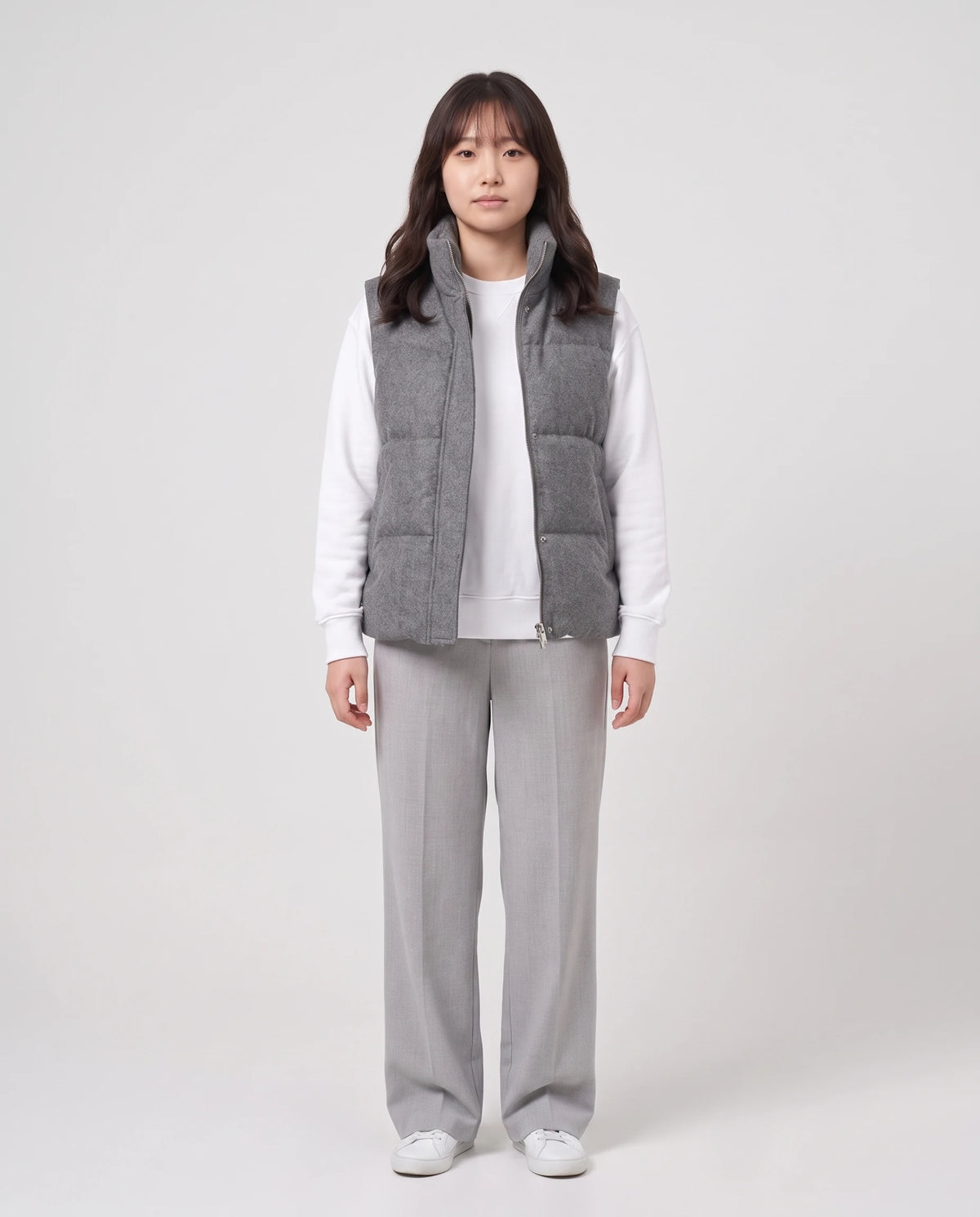 Gilet matelassé en lainage chiné à col montant Roxanne en Gris Anthracite Chiné, porté ouvert sur un sweat blanc, zip descendu