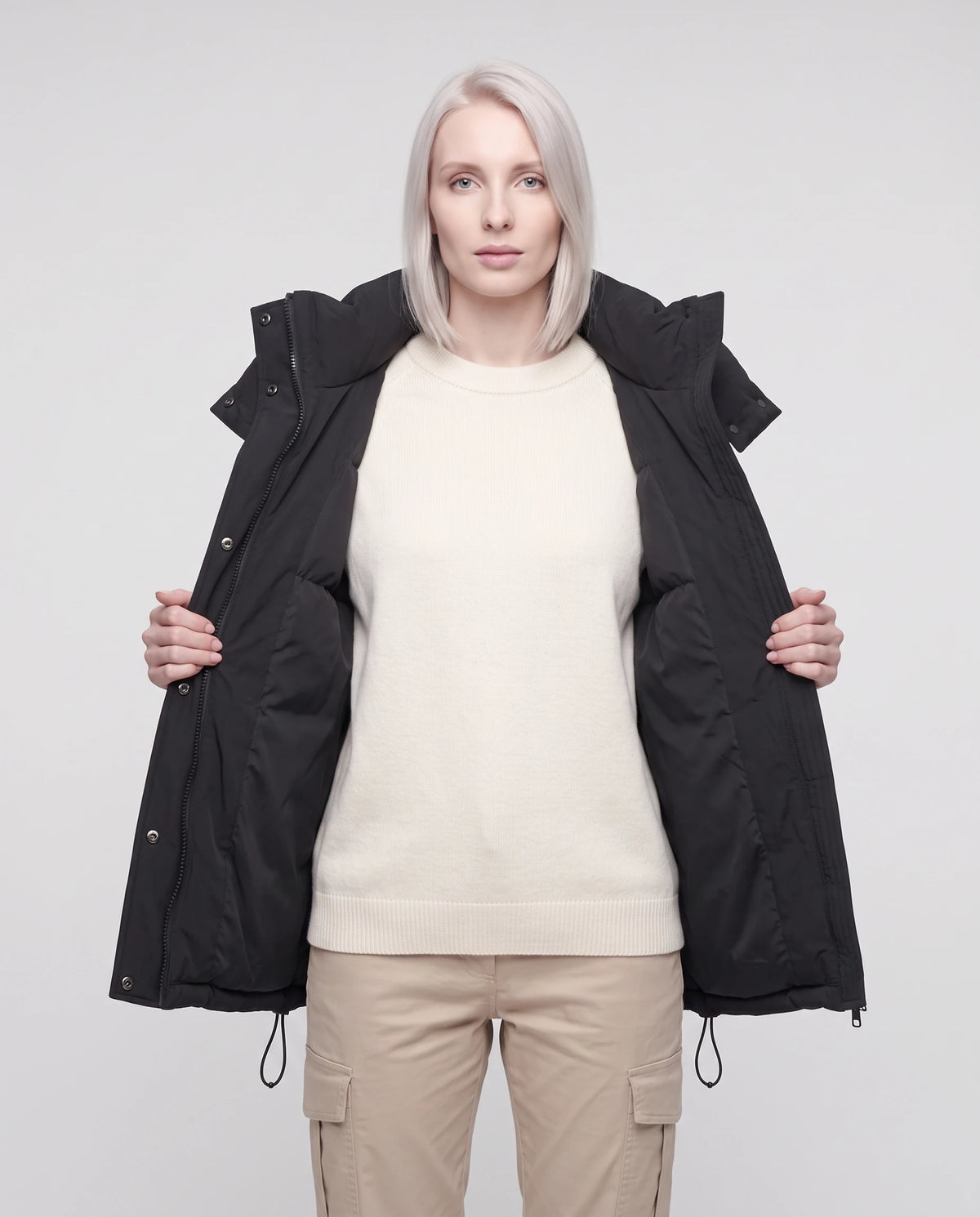 Gilet matelassé oversize à capuche amovible Patricia en Noir, porté ouvert sur un sweat écru, plan rapproché
