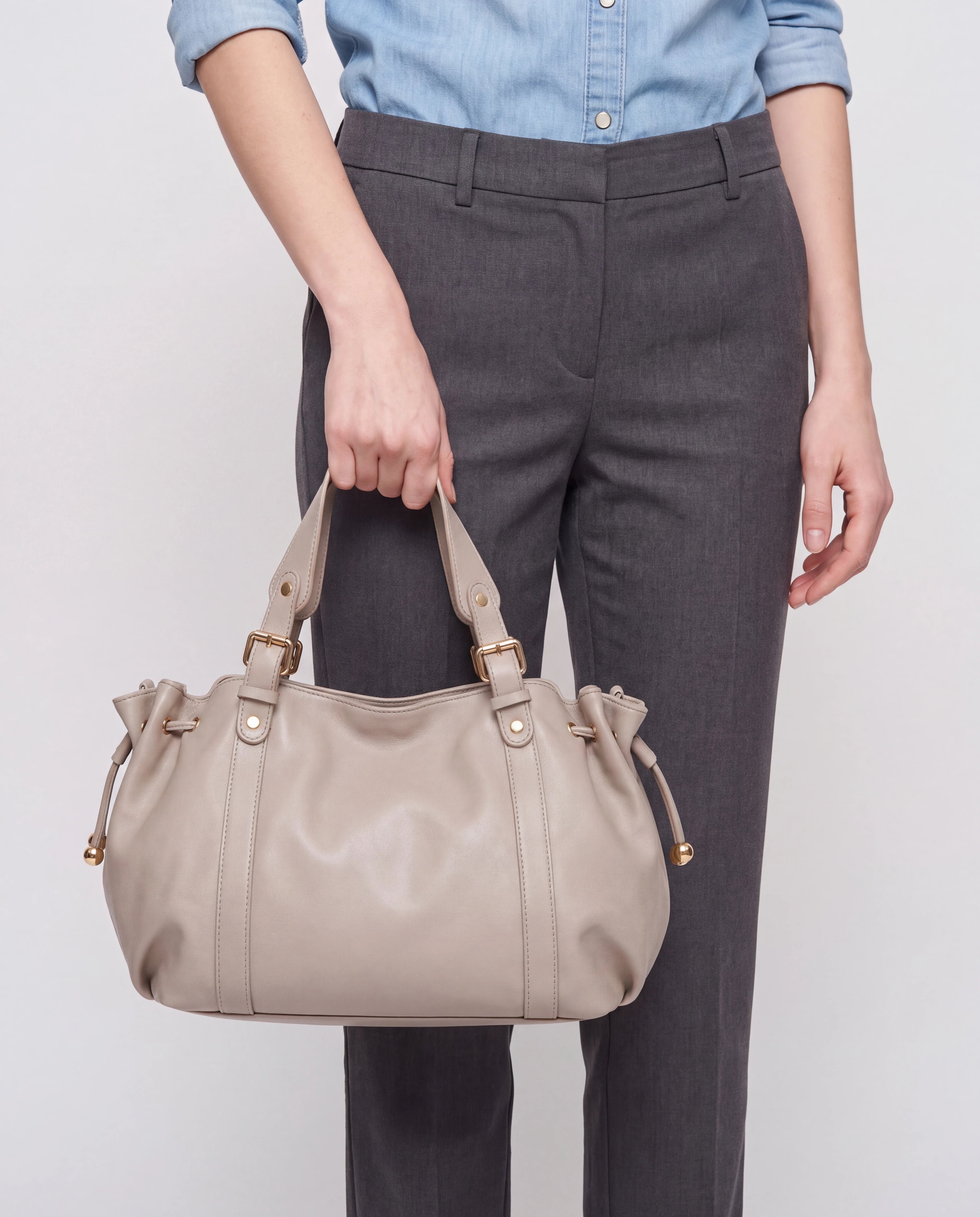 Grand sac à main de cours bowling souple Enora coloris Beige — porté à la main à hauteur de hanche