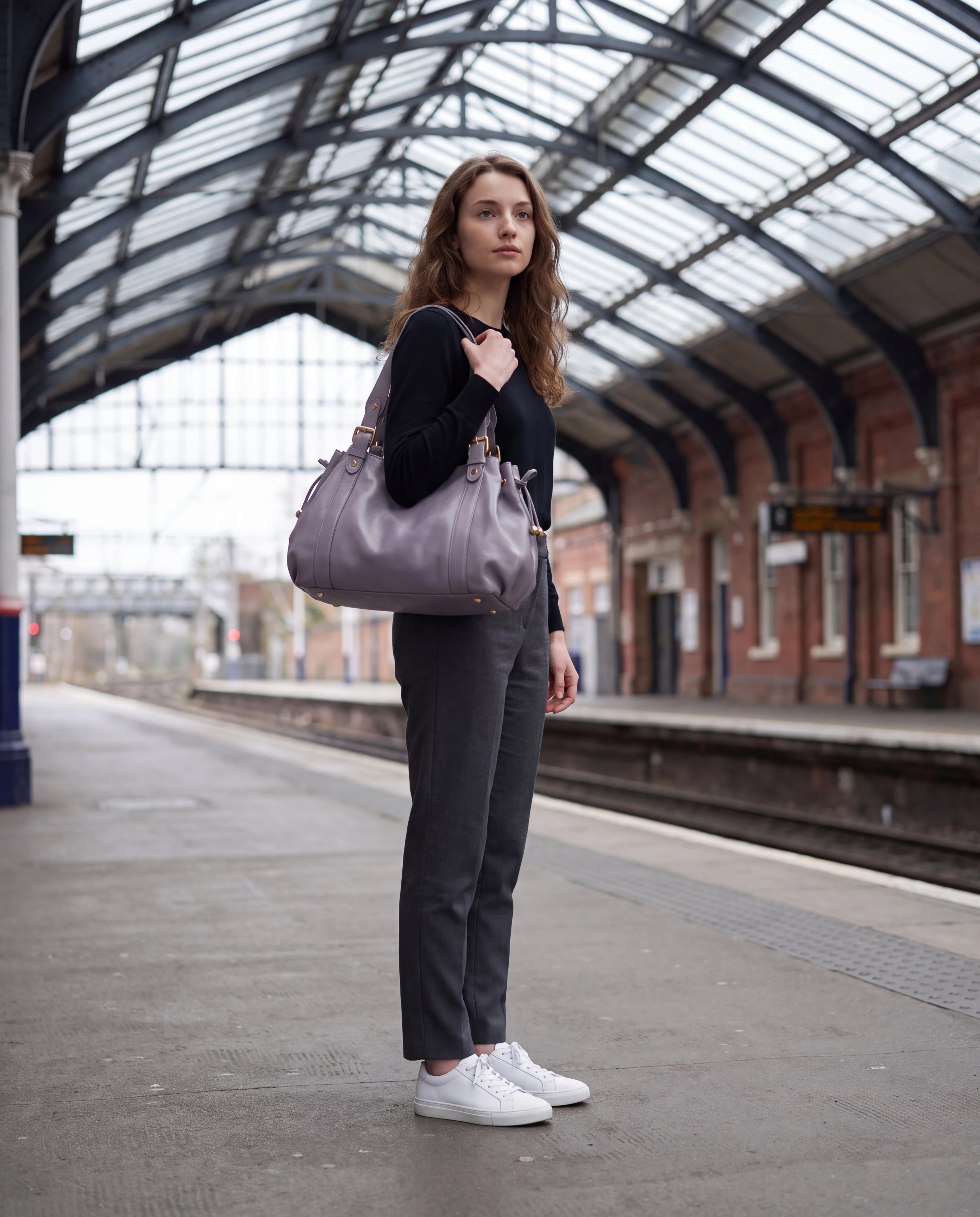 Grand sac à main de cours bowling souple Enora coloris Gris Lilas — porté sur un quai de gare