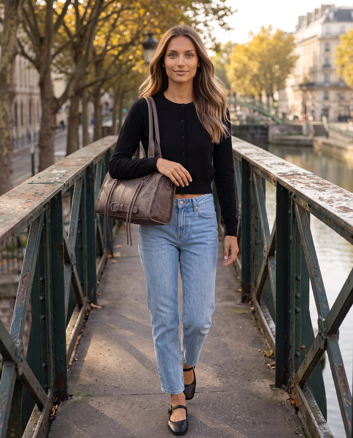 Grand sac à main bowling bandoulière style motard à lacets Avril coloris Brun Cacao, porté à l'épaule sous le bras sur une passerelle au-dessus d'un canal