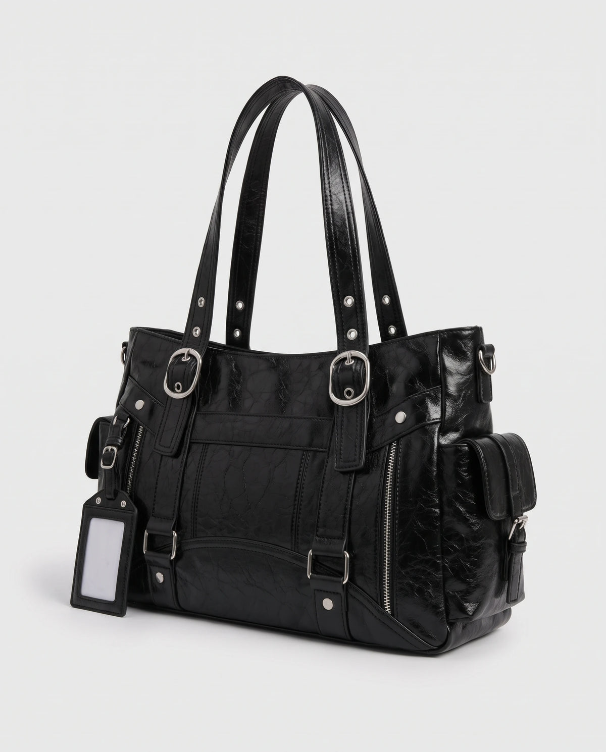 Grand sac à main cabas de cours style motard à boucles Pia coloris Noir, vue de trois quarts sur la poche latérale à rabat sanglé et l'anneau latéral