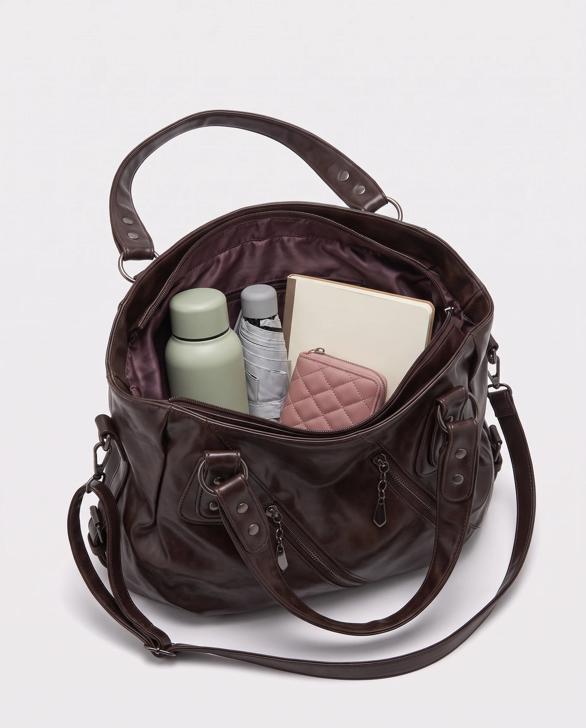 Grand sac à main hobo bandoulière style motard à zips Thelma coloris Chocolat Foncé, intérieur rempli d'une gourde, d'un parapluie pliant, d'un portefeuille et d'un carnet