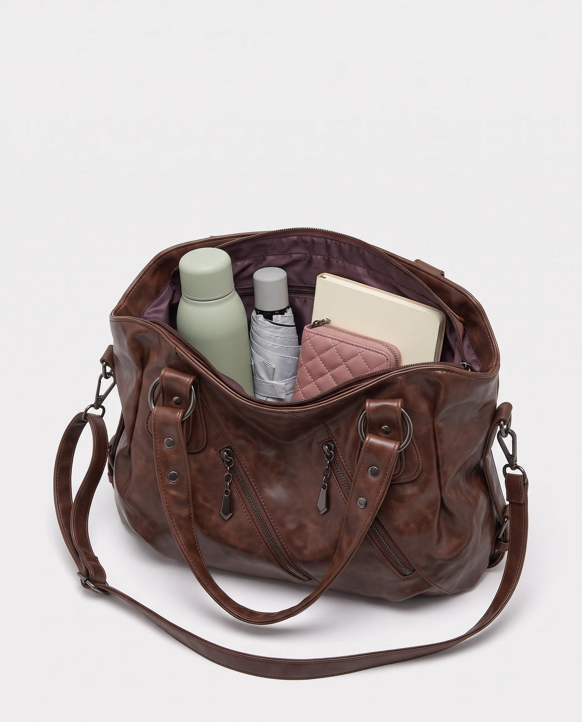 Grand sac à main hobo bandoulière style motard à zips Thelma coloris Marron Châtaigne, intérieur rempli d'une gourde, d'un parapluie pliant, d'un portefeuille et d'un carnet
