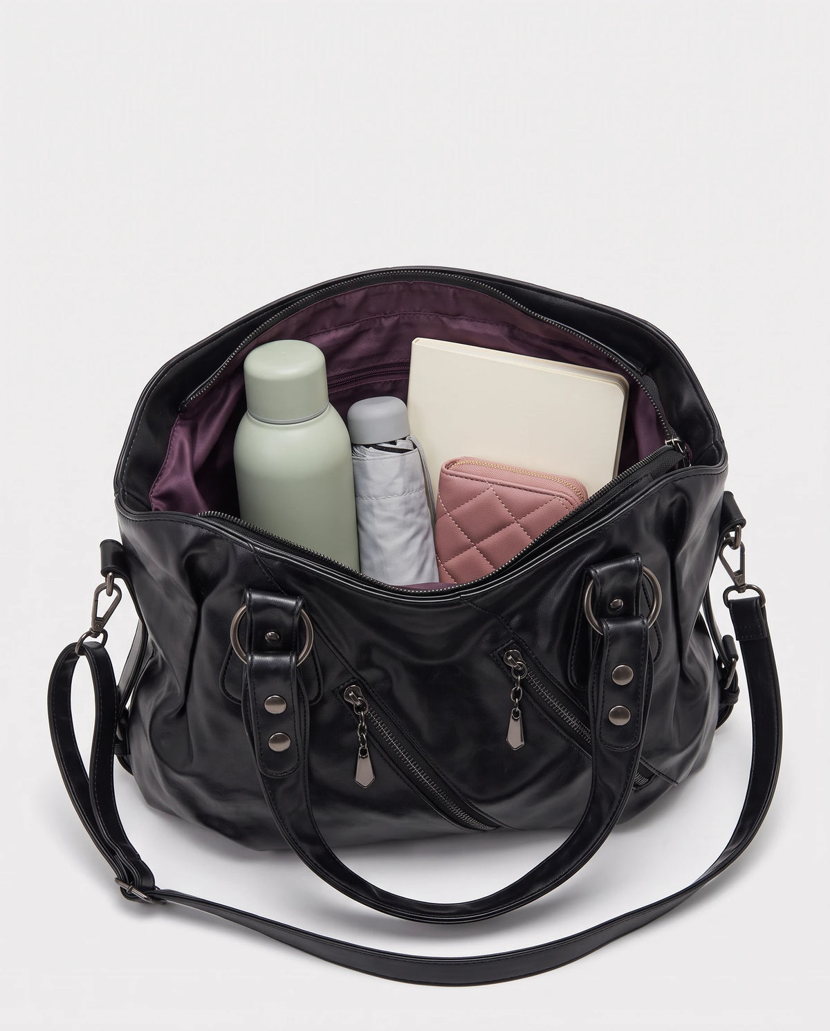 Grand sac à main hobo bandoulière style motard à zips Thelma coloris Noir, intérieur rempli d'une gourde, d'un parapluie pliant, d'un portefeuille et d'un carnet