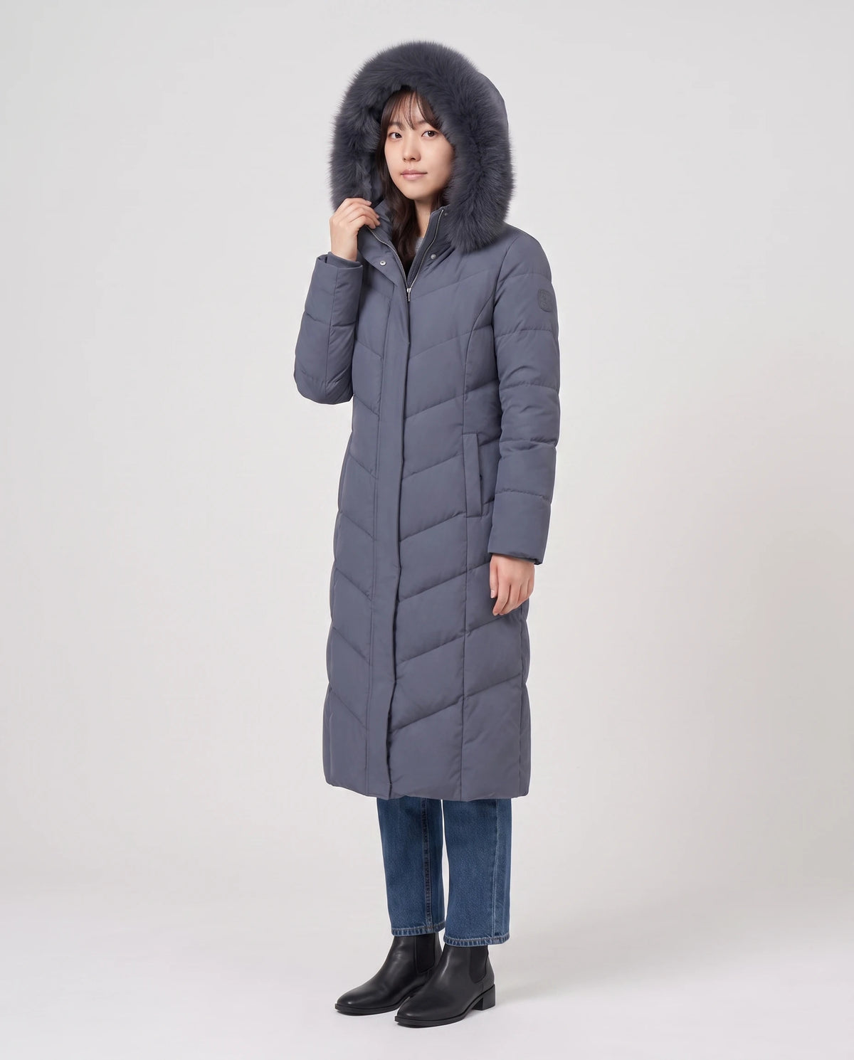 Lange taillierte Parka mit Kunstfellkapuze Noa in Schieferblau, Dreiviertelansicht, Kunstfellkapuze aufgesetzt