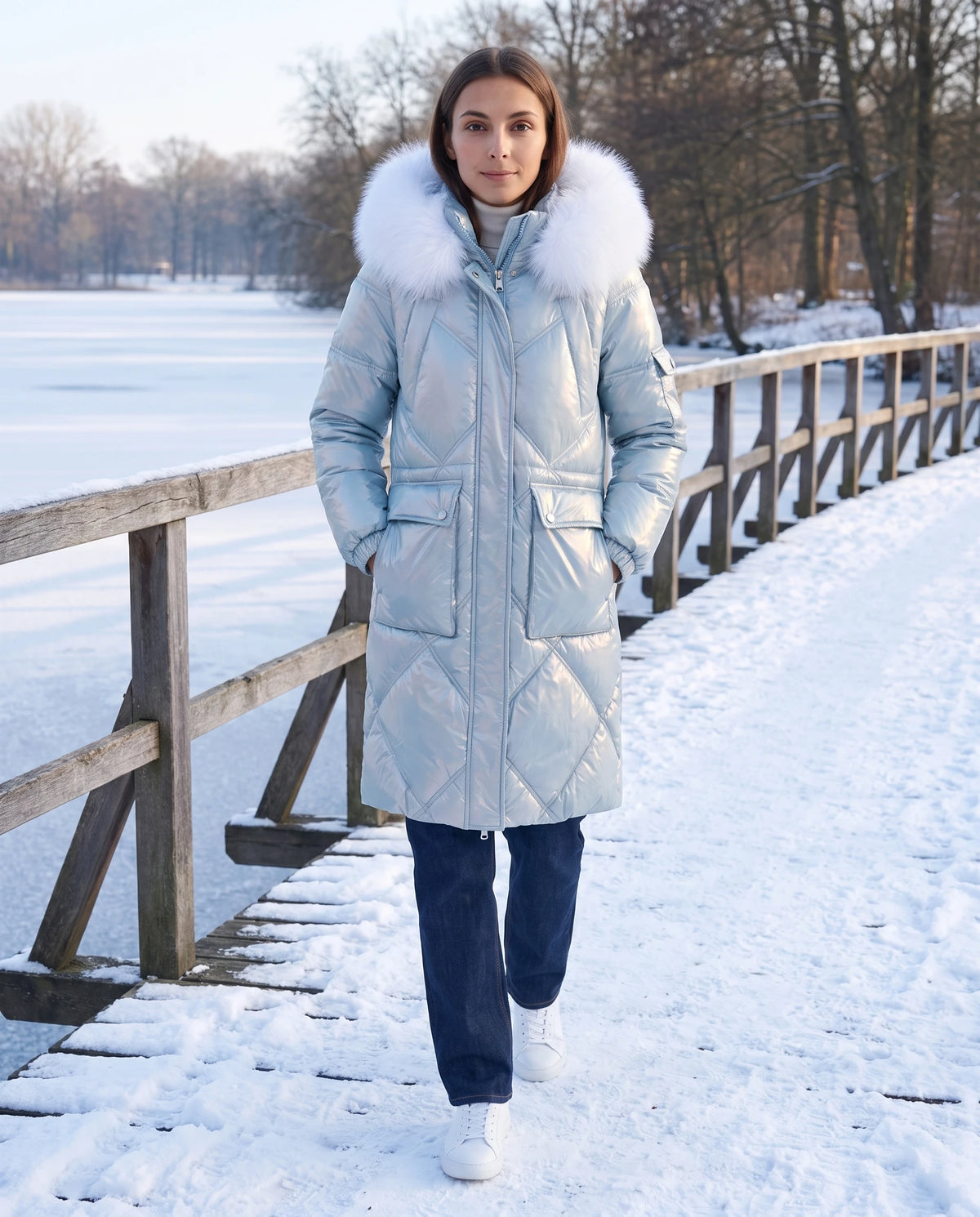 Parka mi-longue brillante à capuche fausse fourrure Vanessa en Bleu Ciel, portée sur une promenade de bord de lac gelé