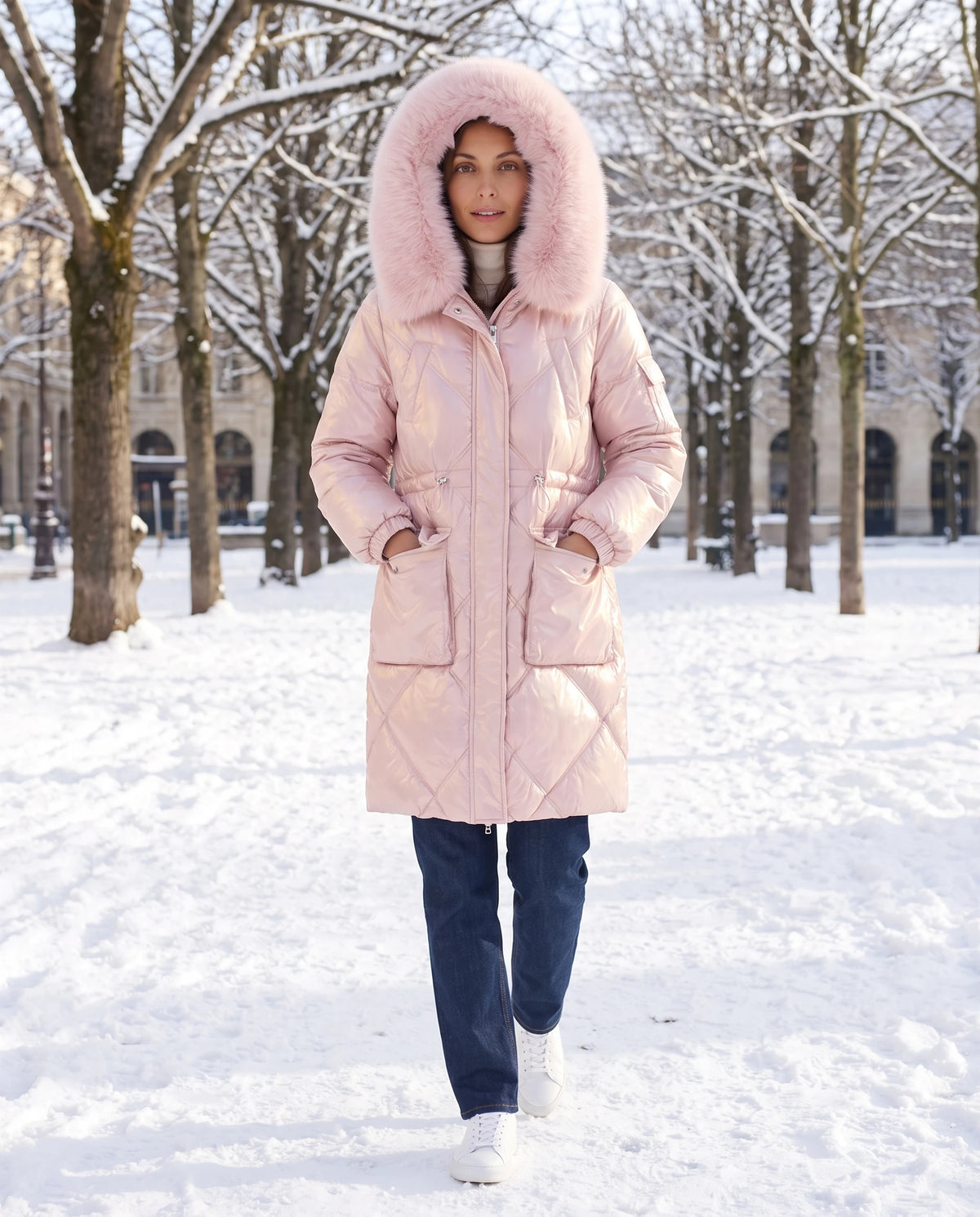 Parka mi-longue brillante à capuche fausse fourrure Vanessa en Rose, portée sur une place enneigée aux arbres nus, capuche relevée