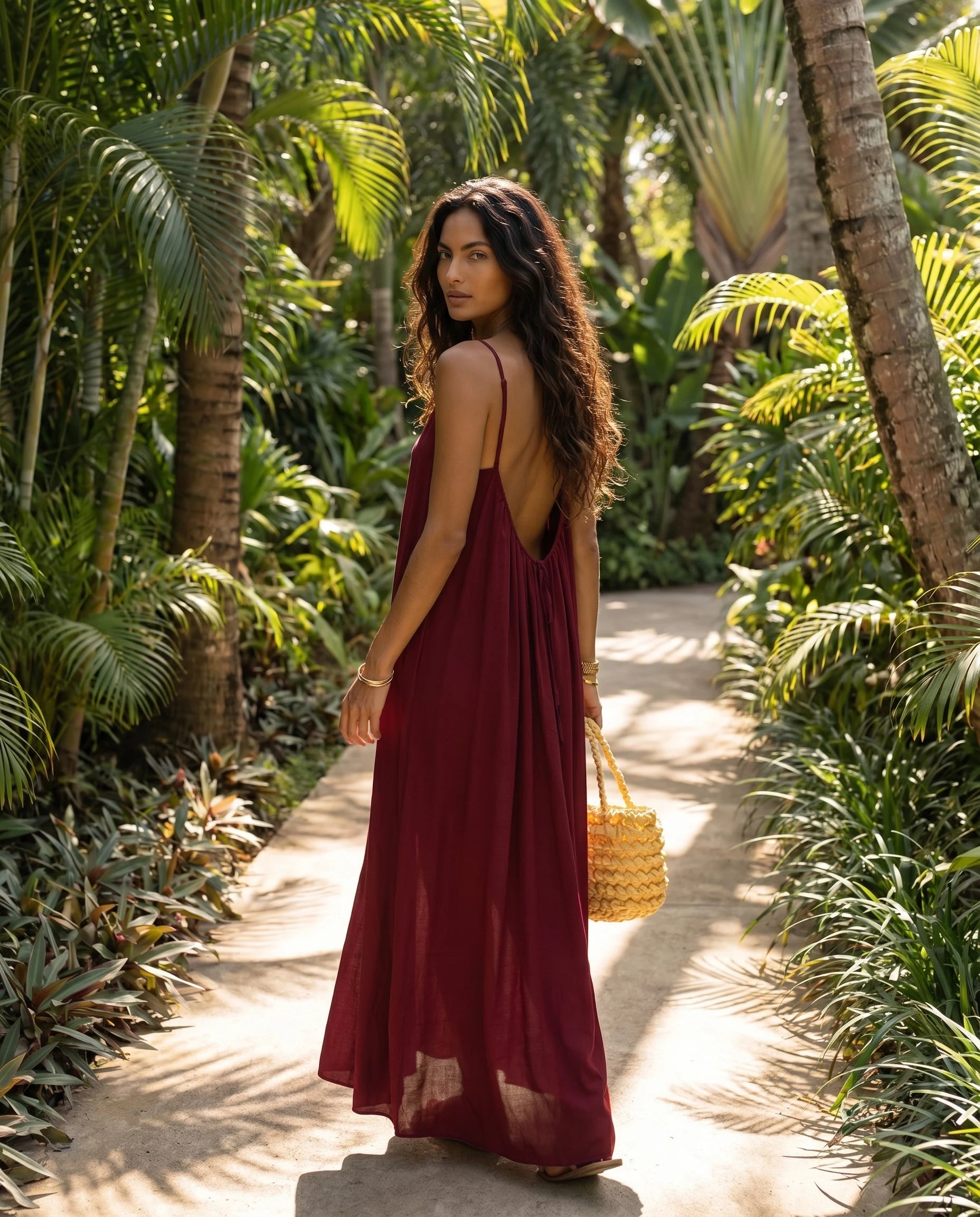 Robe longue trapèze dos nu bordeaux Zolena, vue de dos en allee tropicale