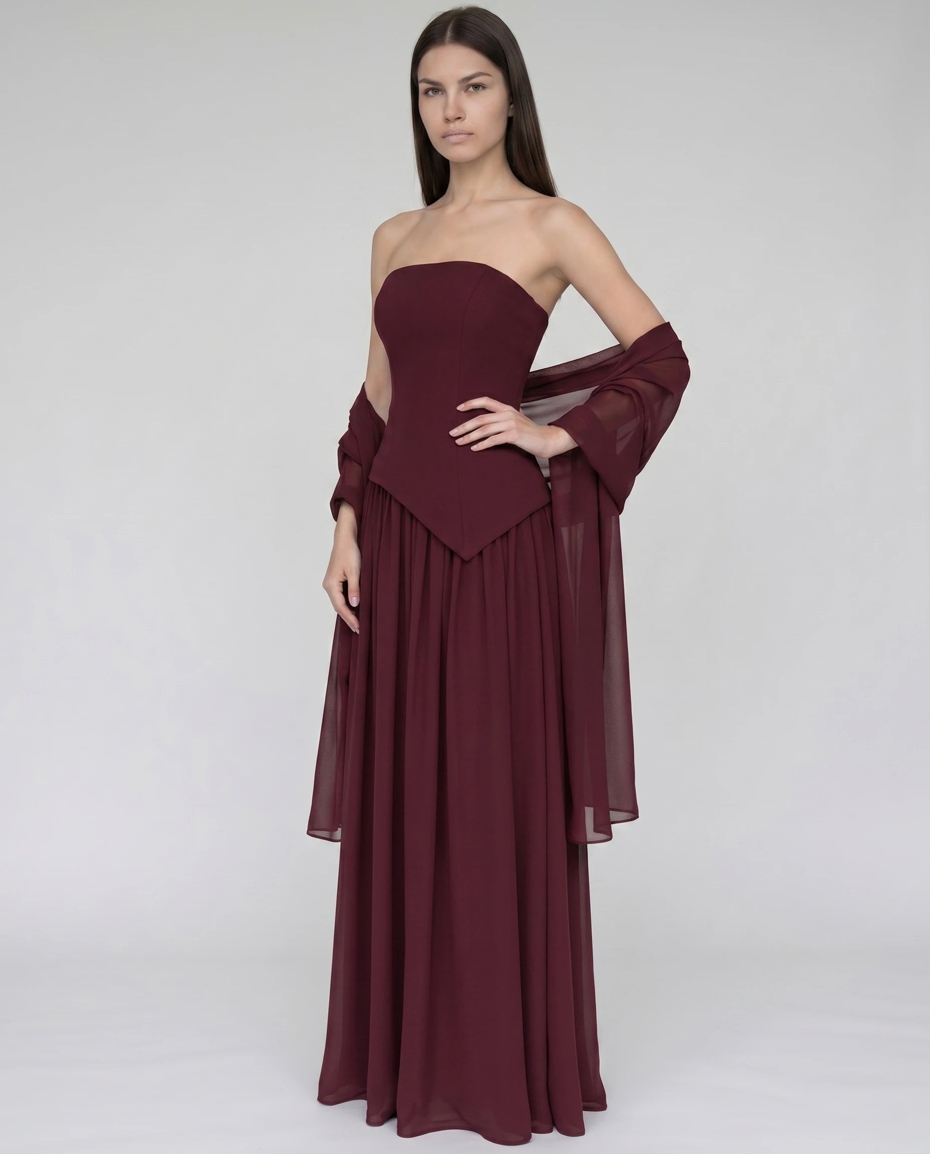 Robe longue bustier asymetrique bordeaux, bustier sculpte et jupe chiffon a fente (vue trois-quarts plein pied)