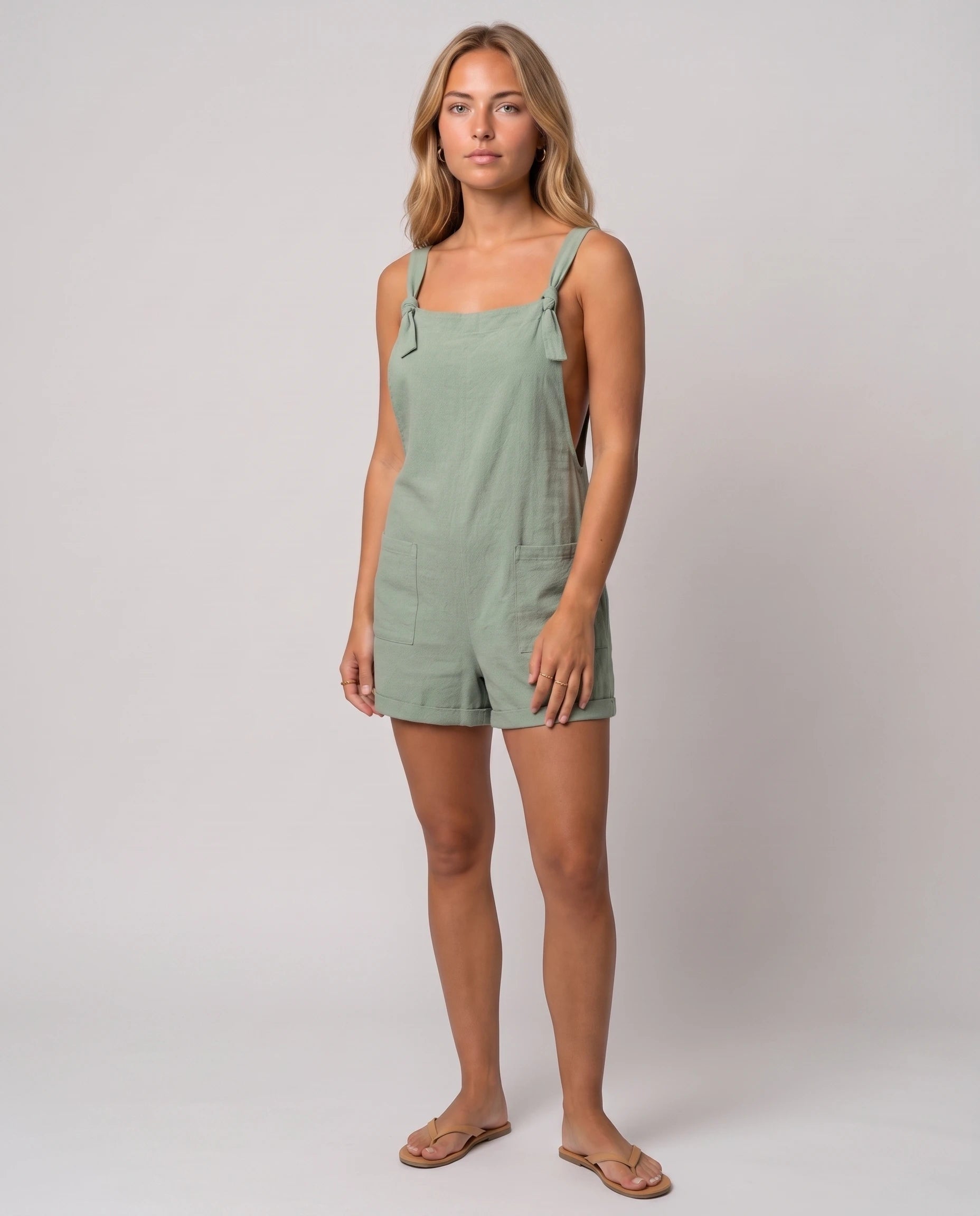 Salopette courte à bretelles nouées Bertille, coloris Vert Sauge, vue de trois-quarts en studio