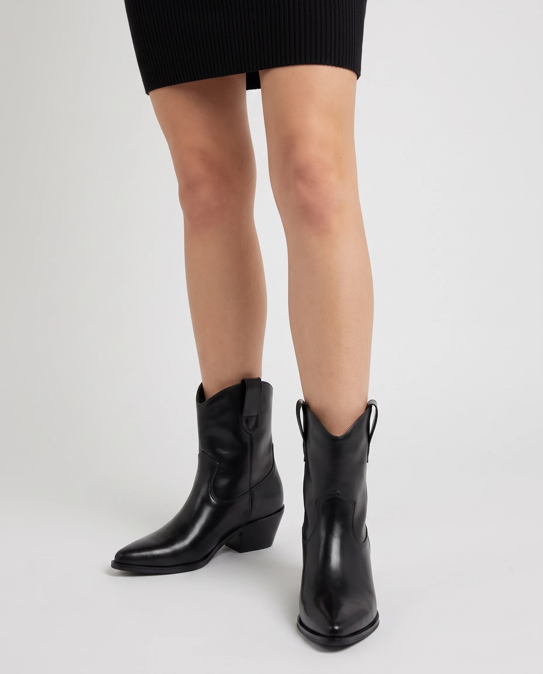 Bottes santiags mi-mollet effet cuir Maurine — Noir, portées en plan rapproché avec une robe courte en maille