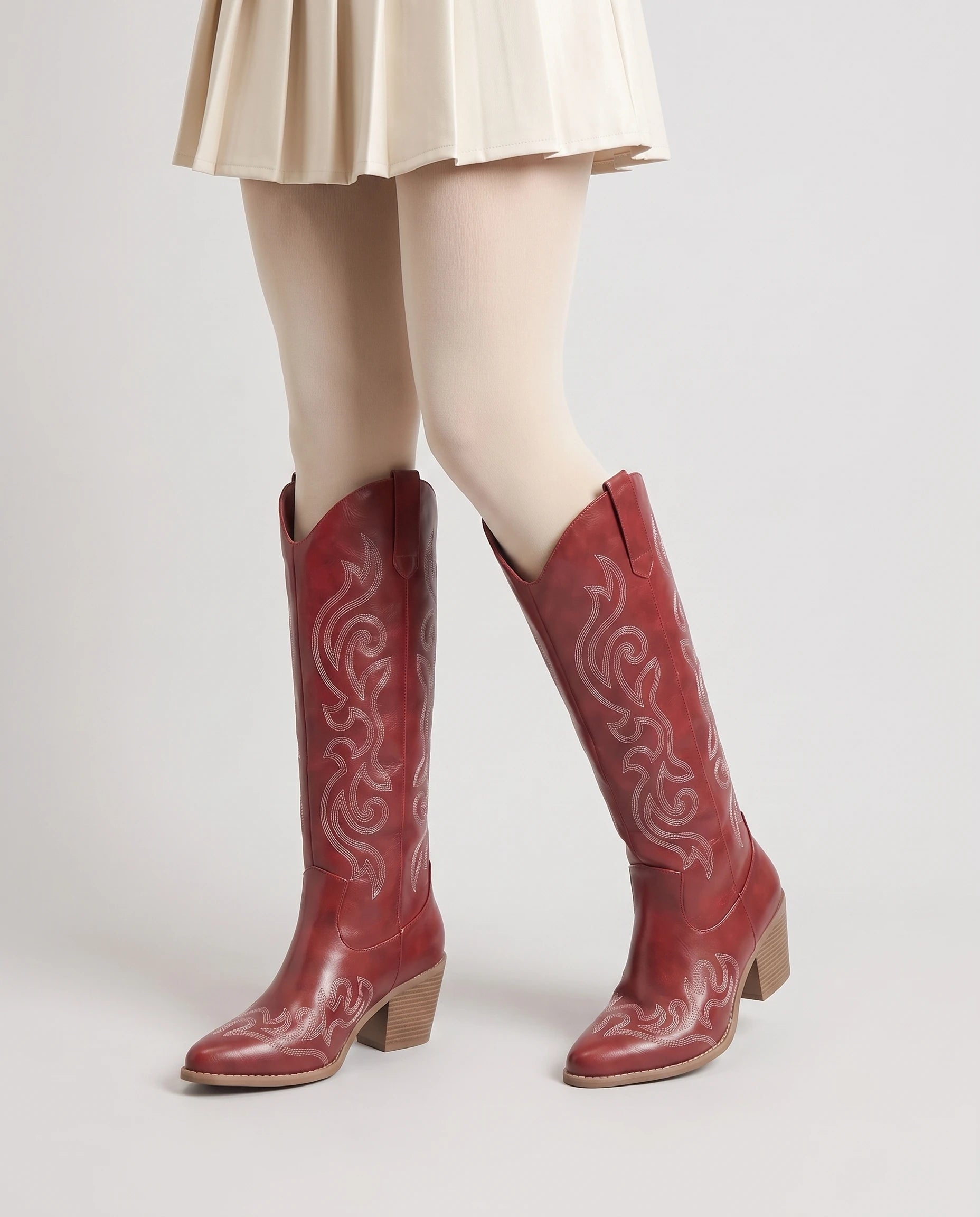 Bottes santiags hautes brodées Ghislaine — Rouge Grenat, portées en plan rapproché, pieds en V ouvert