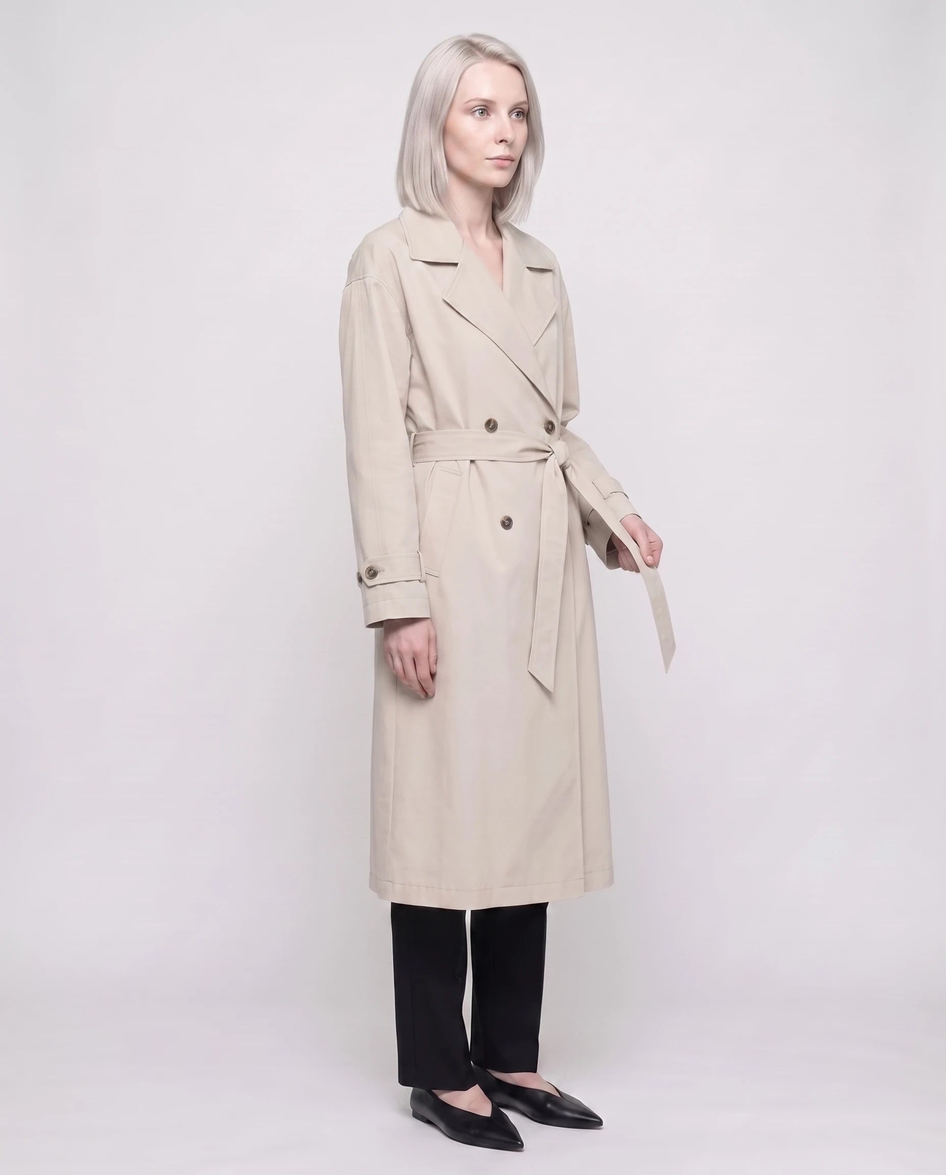 Trench long ample beige Angèle, vue de trois quarts en studio
