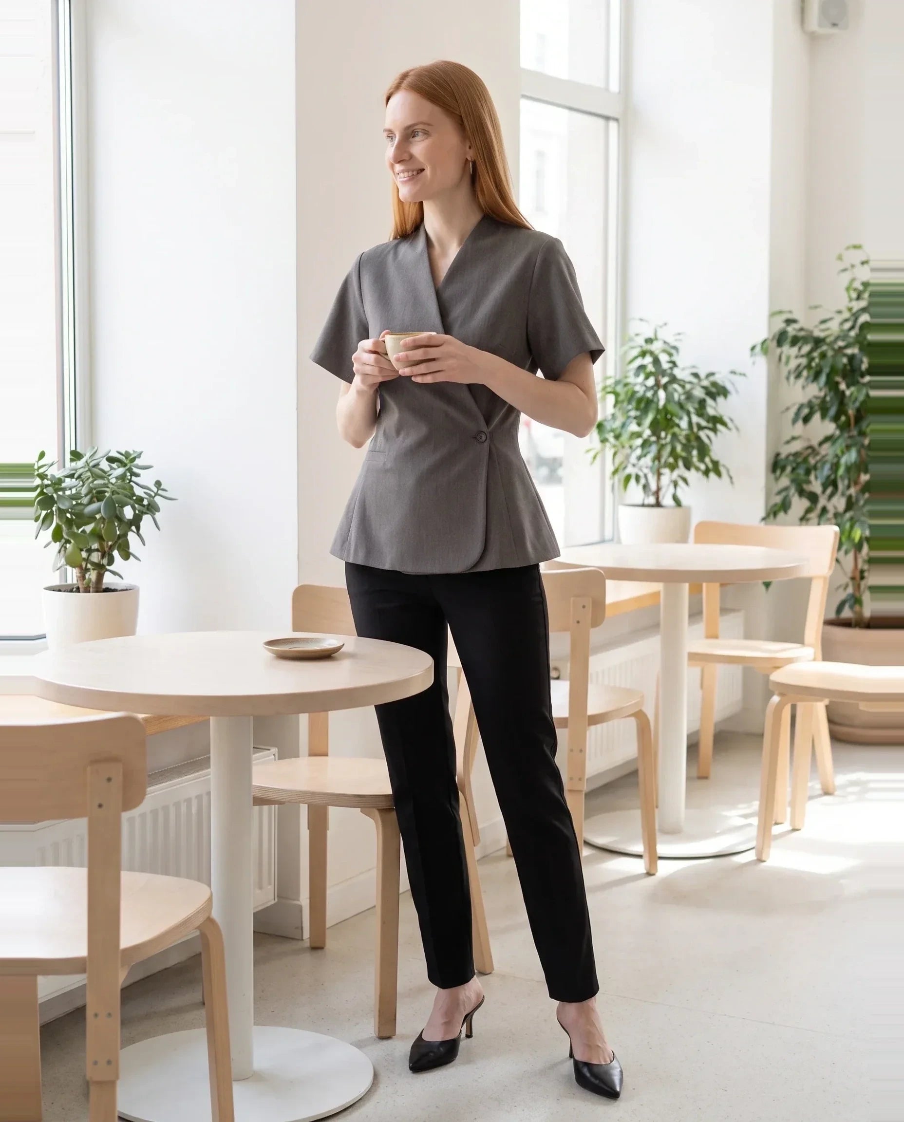 Veste cache-cœur gris chiné Célimène, portée dans un café scandinave lumineux