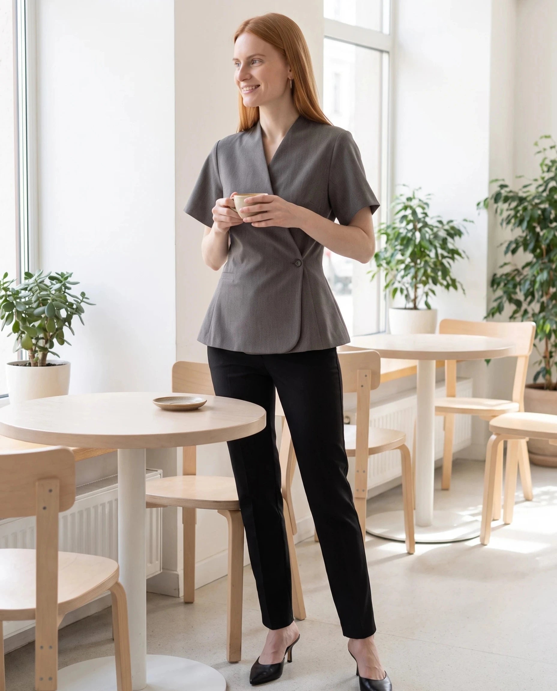 Veste cache-cœur gris chiné Célimène, portée dans un café scandinave lumineux