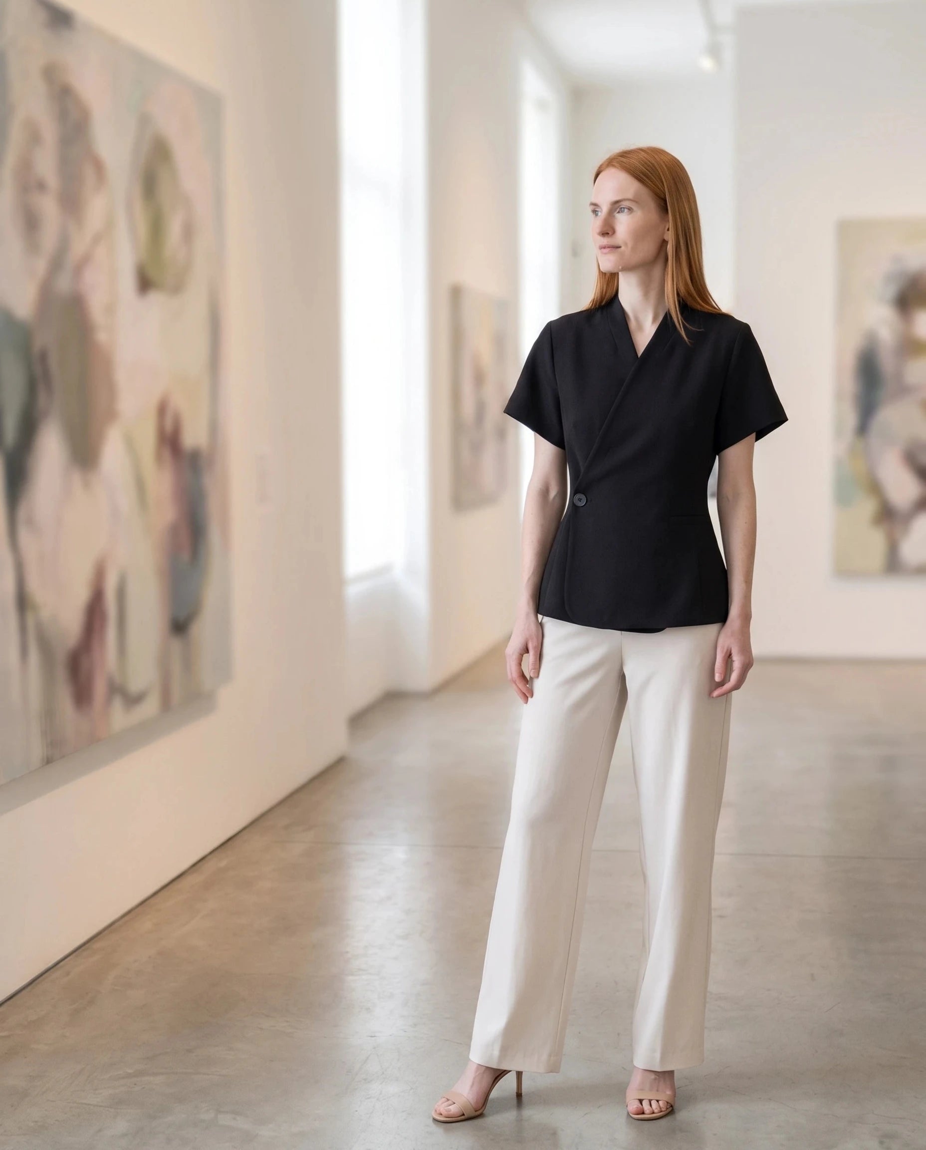 Veste cache-cœur noire Célimène, portée dans une galerie d'art lumineuse