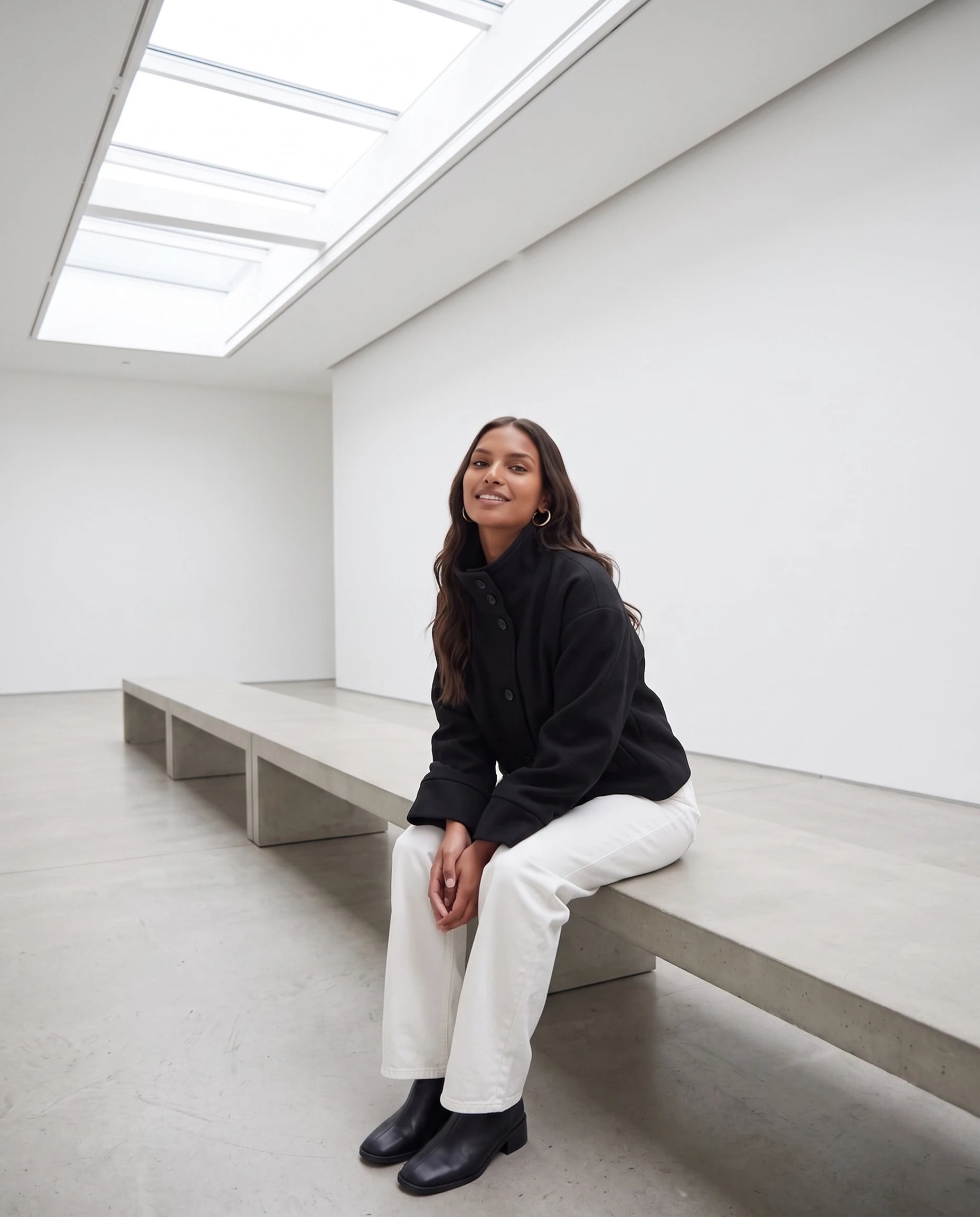 Veste courte à col montant noire Théa, portée dans une galerie lumineuse