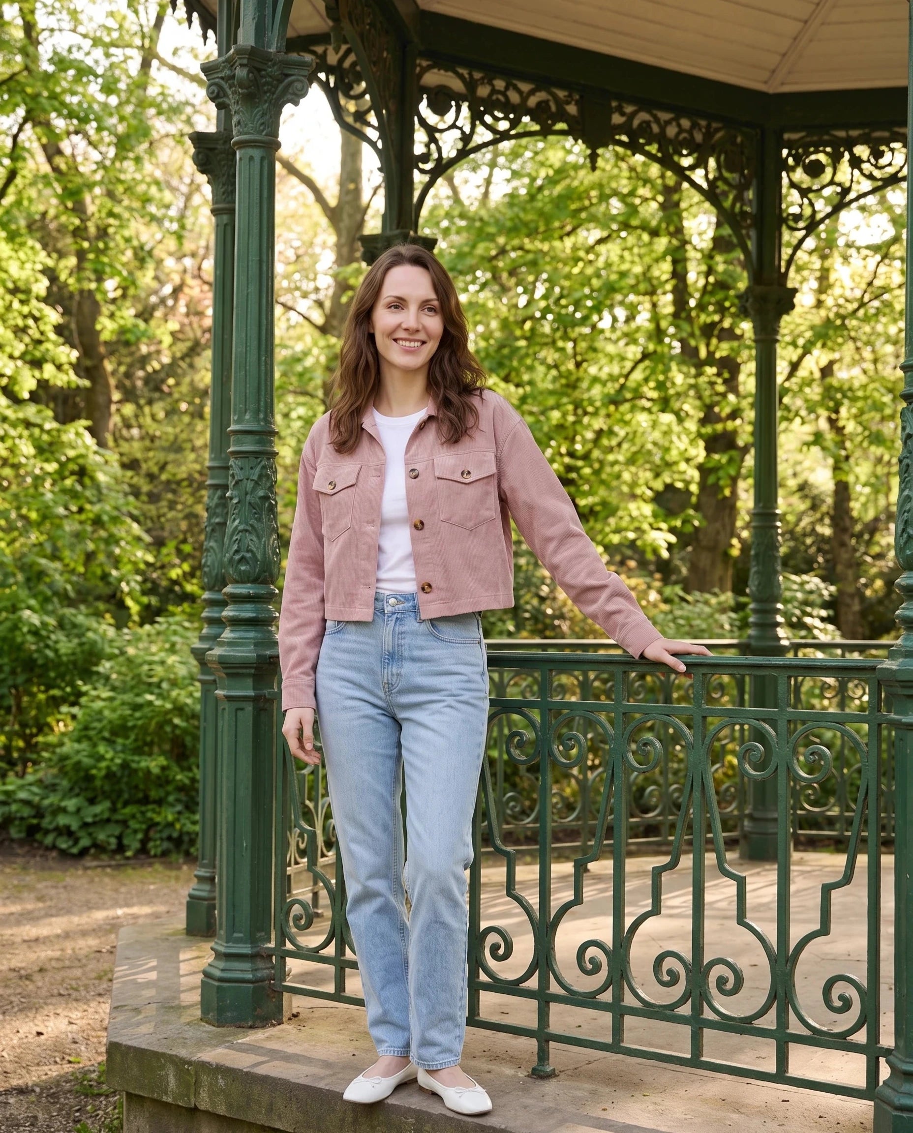 Veste courte en velours côtelé rose poudré Simone, portée près d'un kiosque de parc
