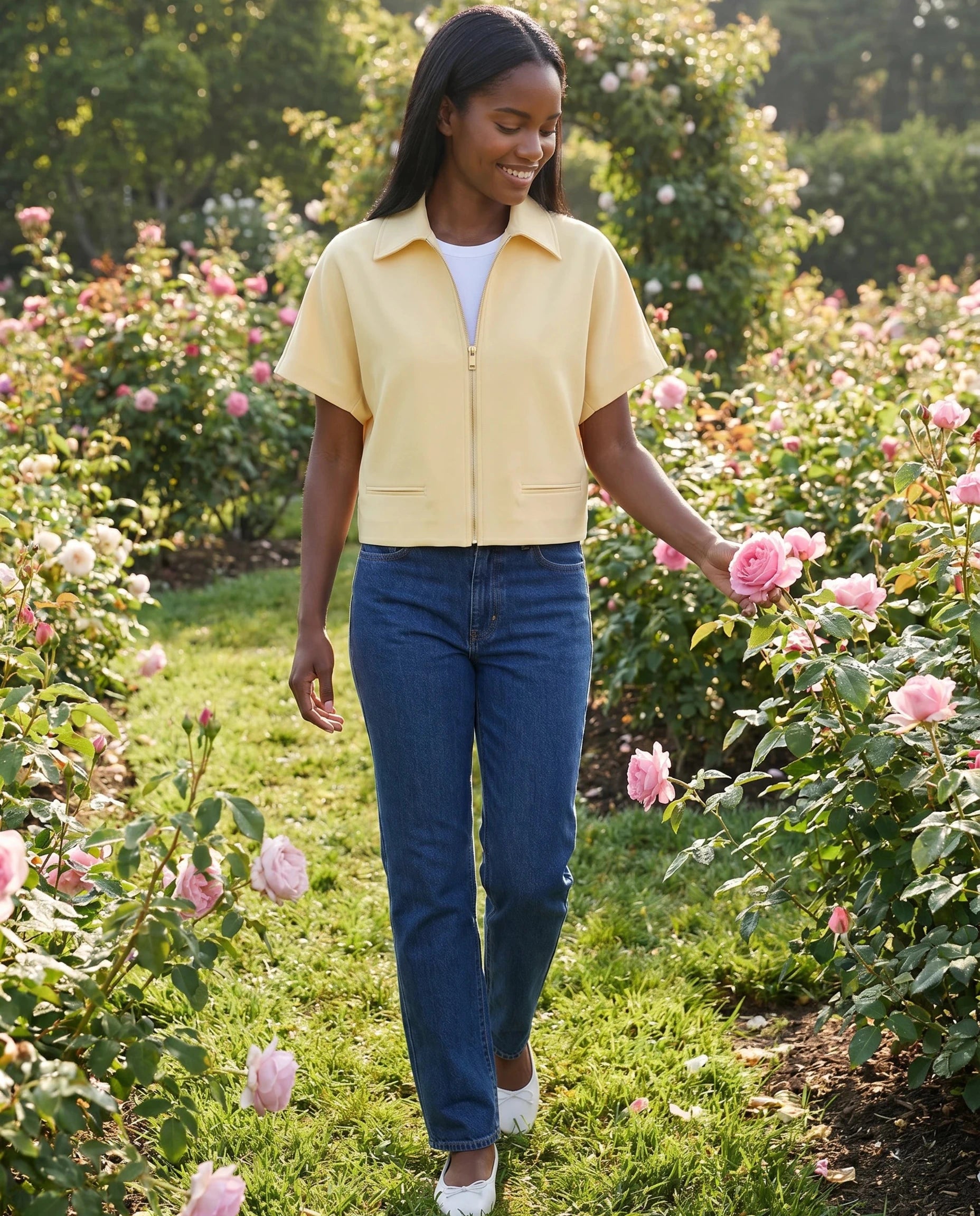 Veste courte zippée jaune pâle Gilberte, portée dans un jardin de roses au matin