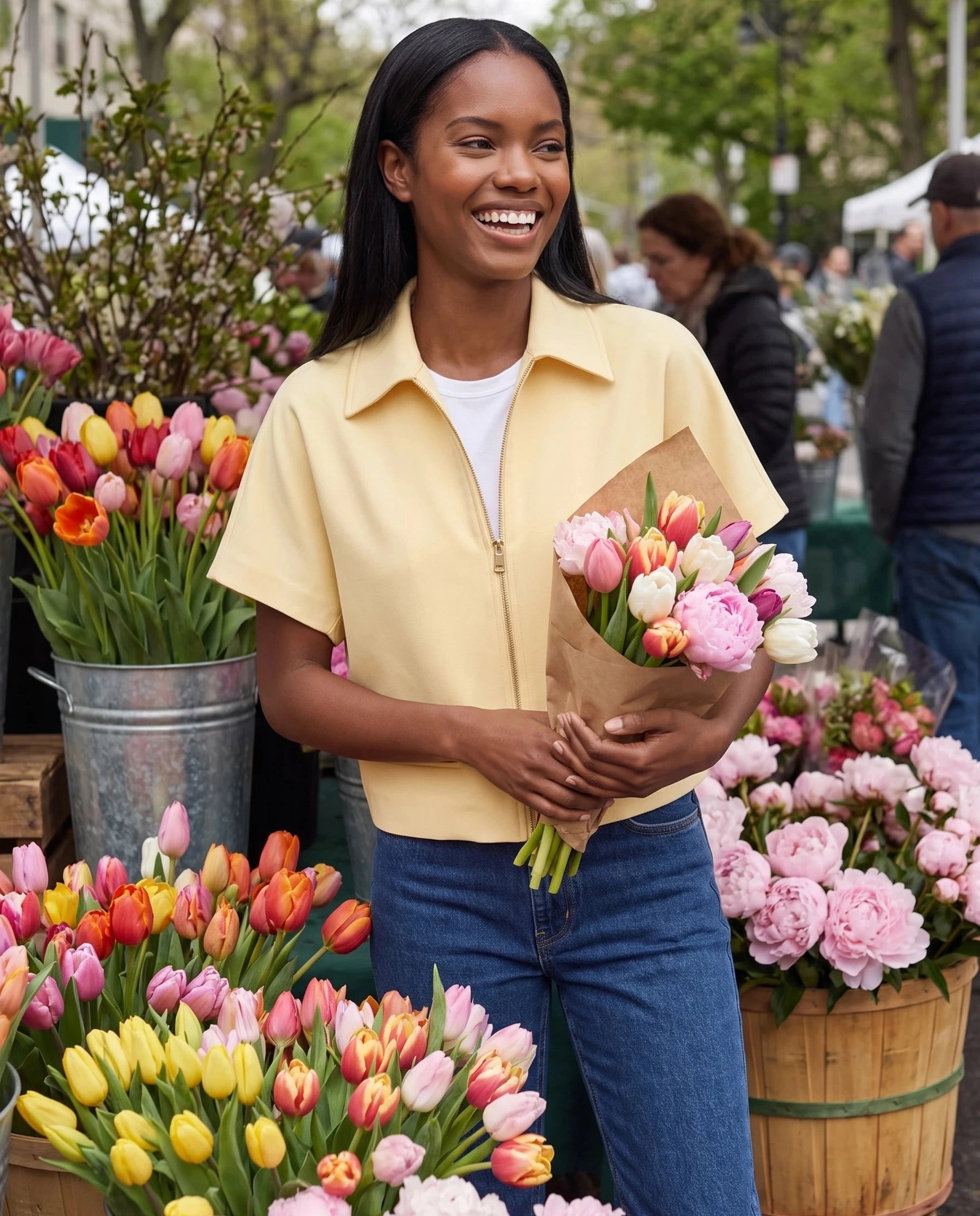 Veste courte zippée jaune pâle Gilberte, portée dans un marché aux fleurs