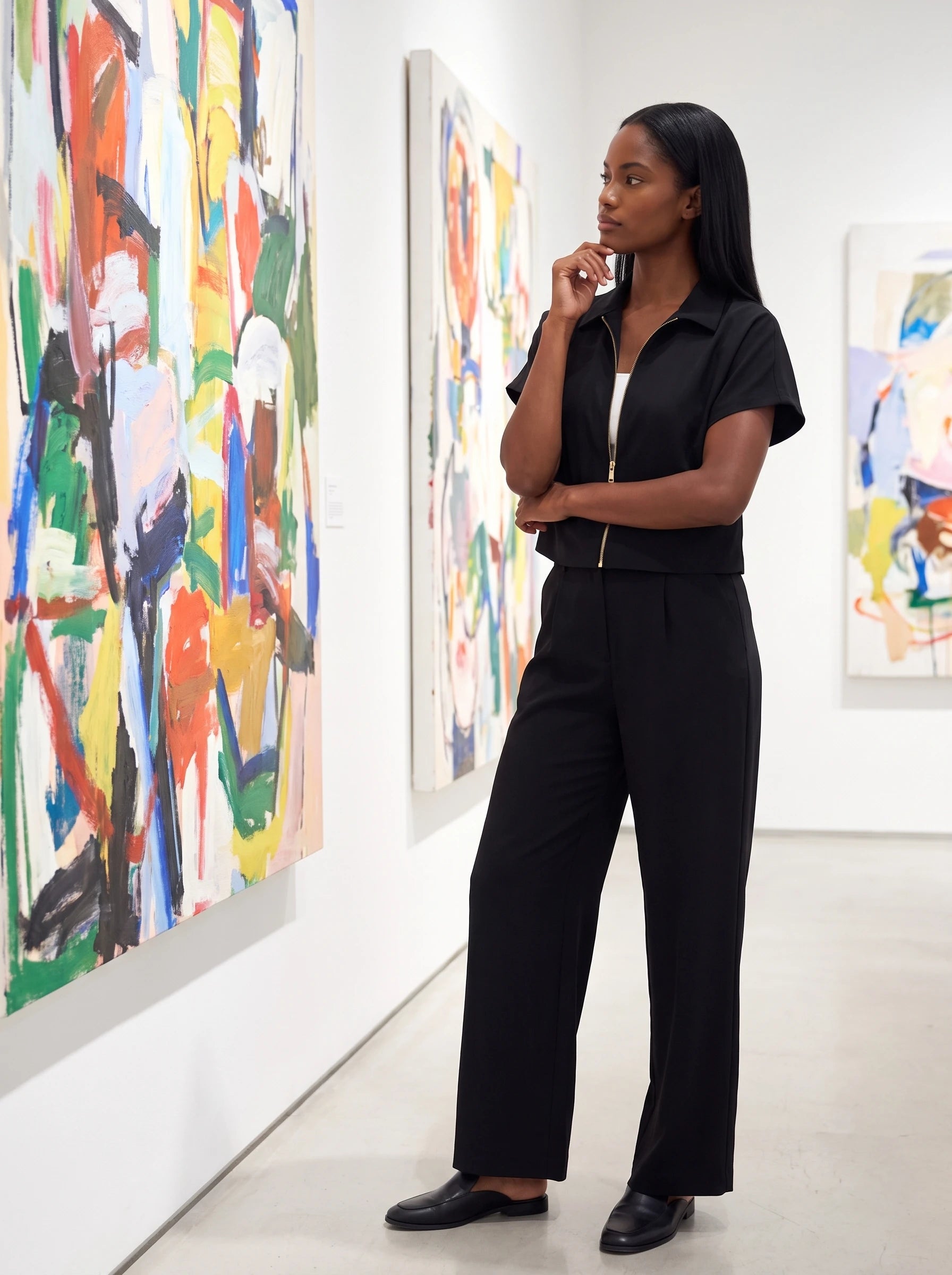Veste courte zippée noire Gilberte, portée dans une galerie d'art moderne
