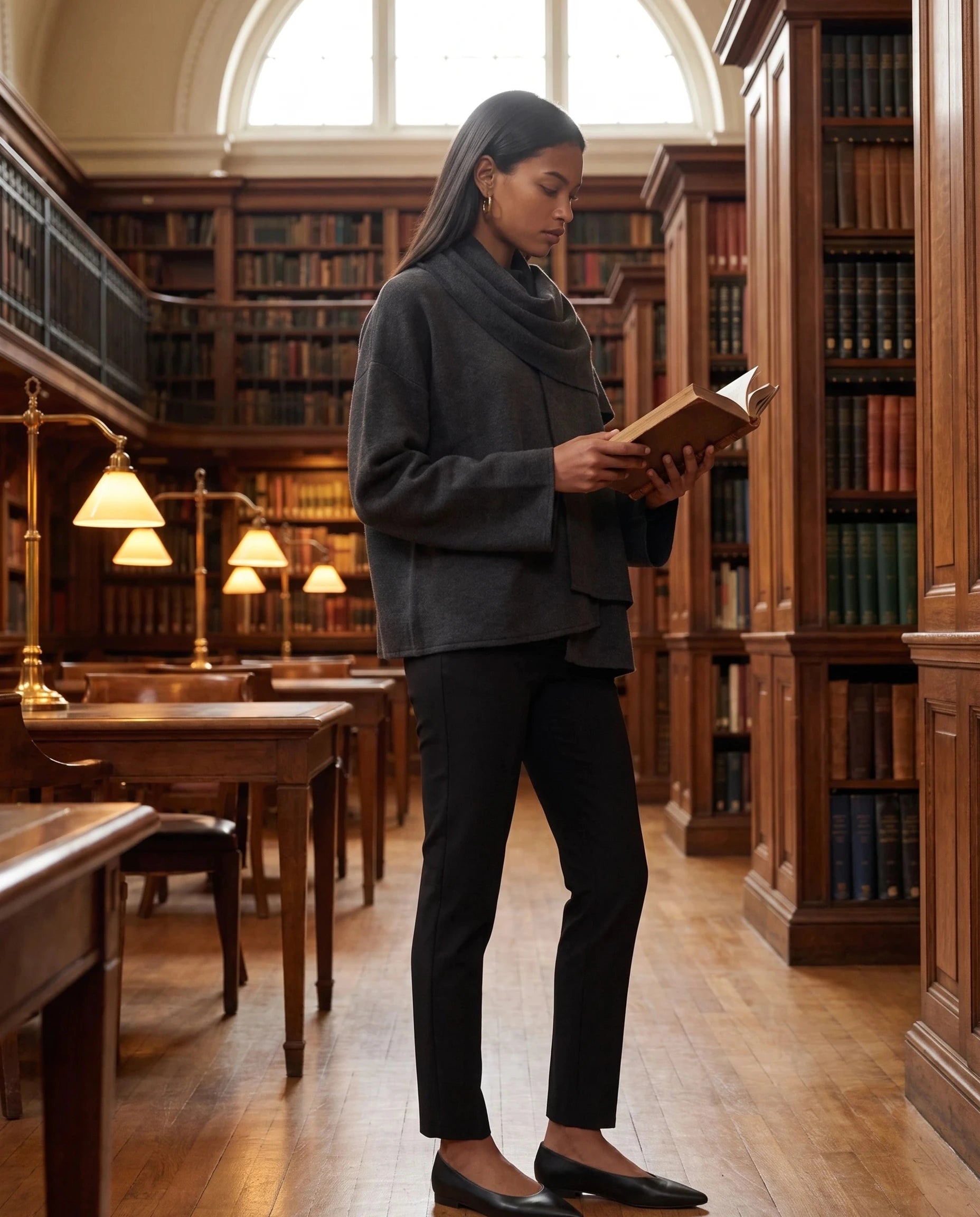 Veste en maille gris anthracite Méline, portée dans une bibliothèque ancienne