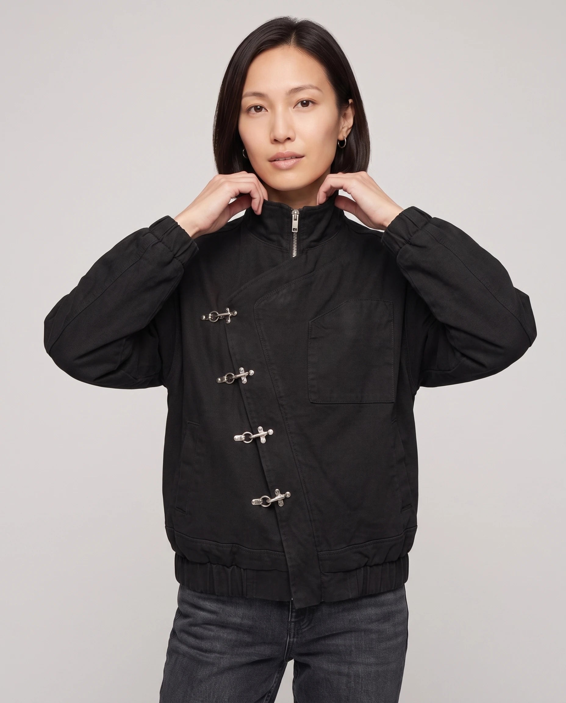 Veste zippée à fermoirs pompier noire Ingrid, plan rapproché en studio