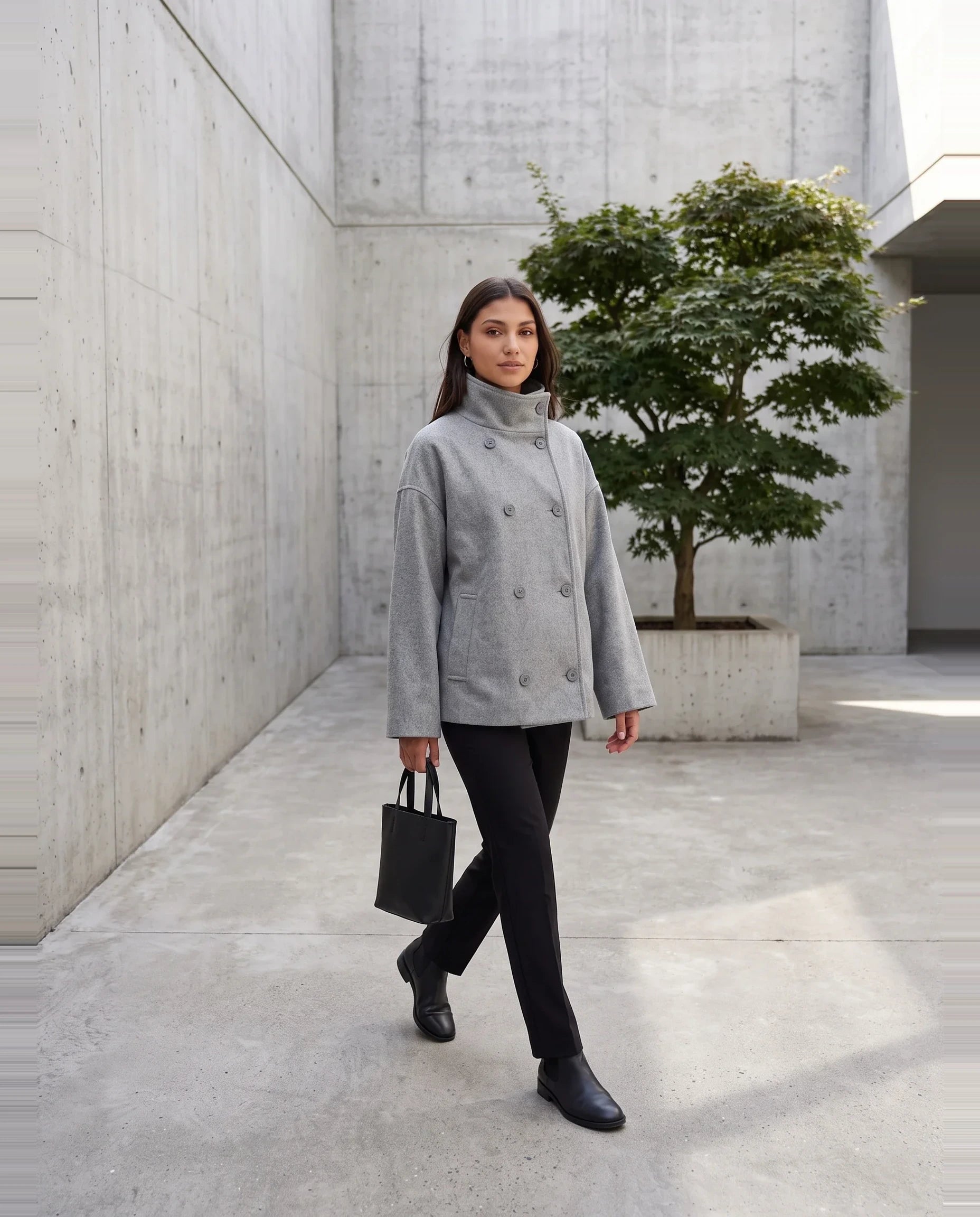 Veste en lainage gris chiné Rosalinde, portée dans une cour minimaliste