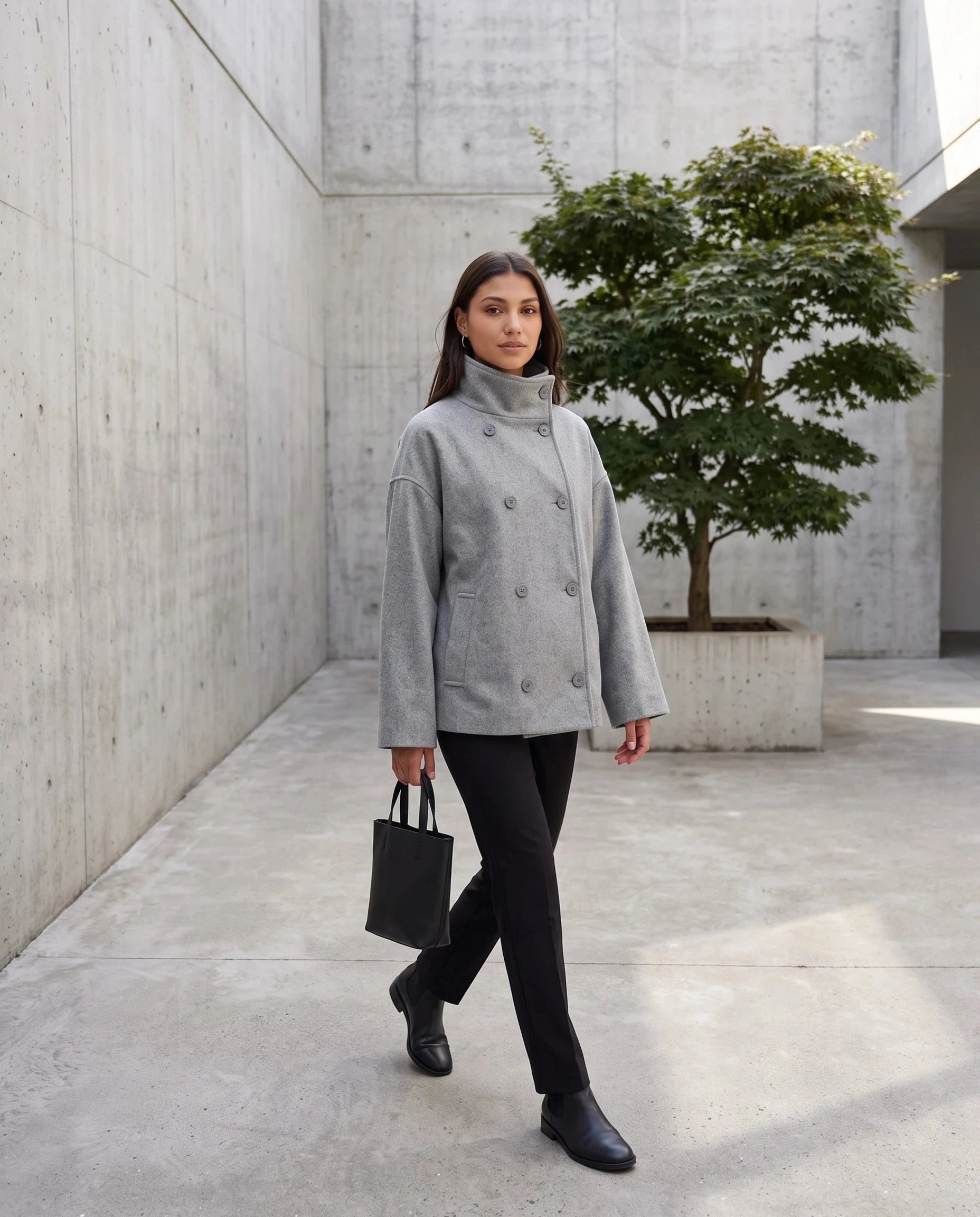 Veste en lainage gris chiné Rosalinde, portée dans une cour minimaliste