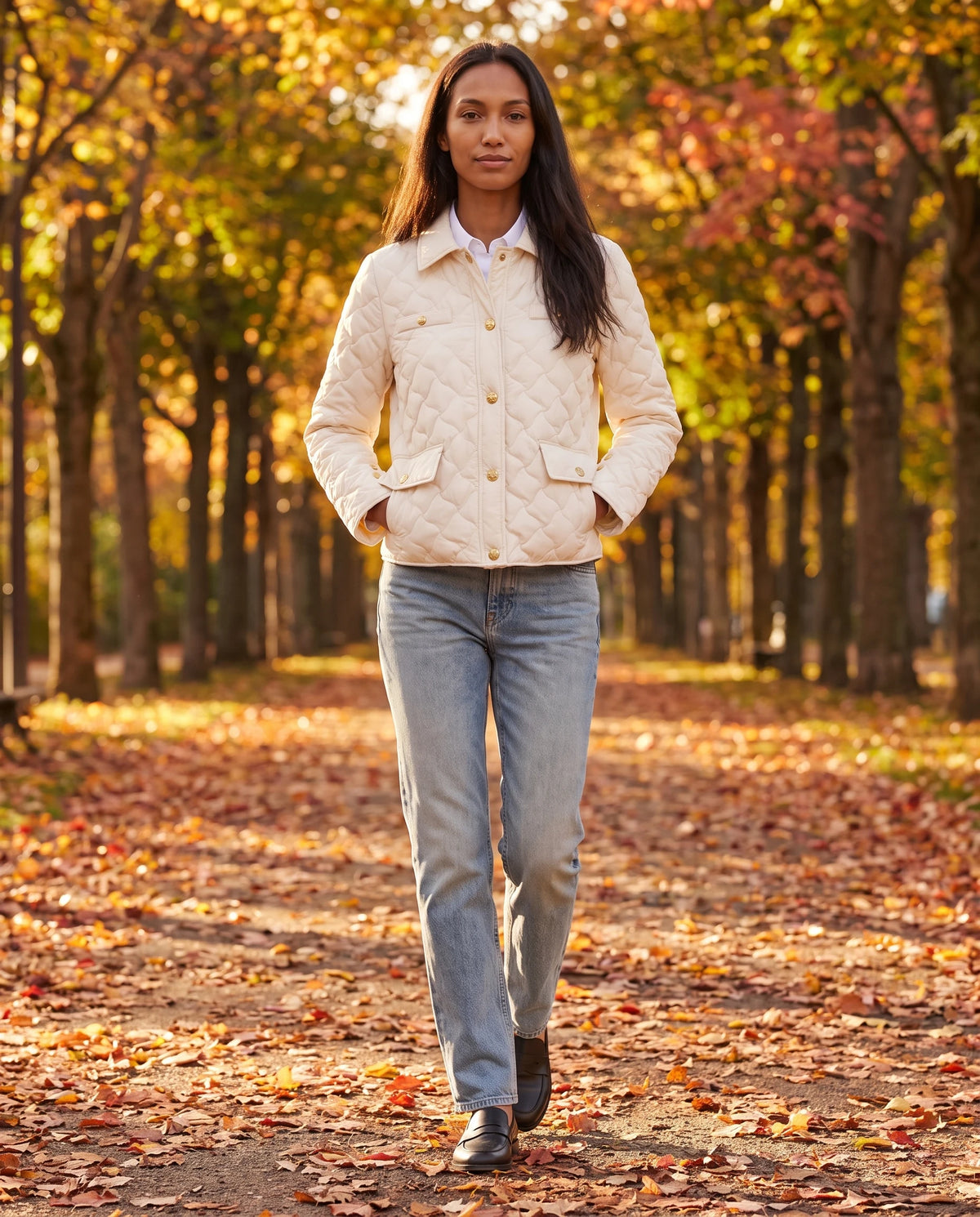 Veste matelassée à col chemise et pressions dorées Mélodie en Écru, portée dans une allée de parc en automne