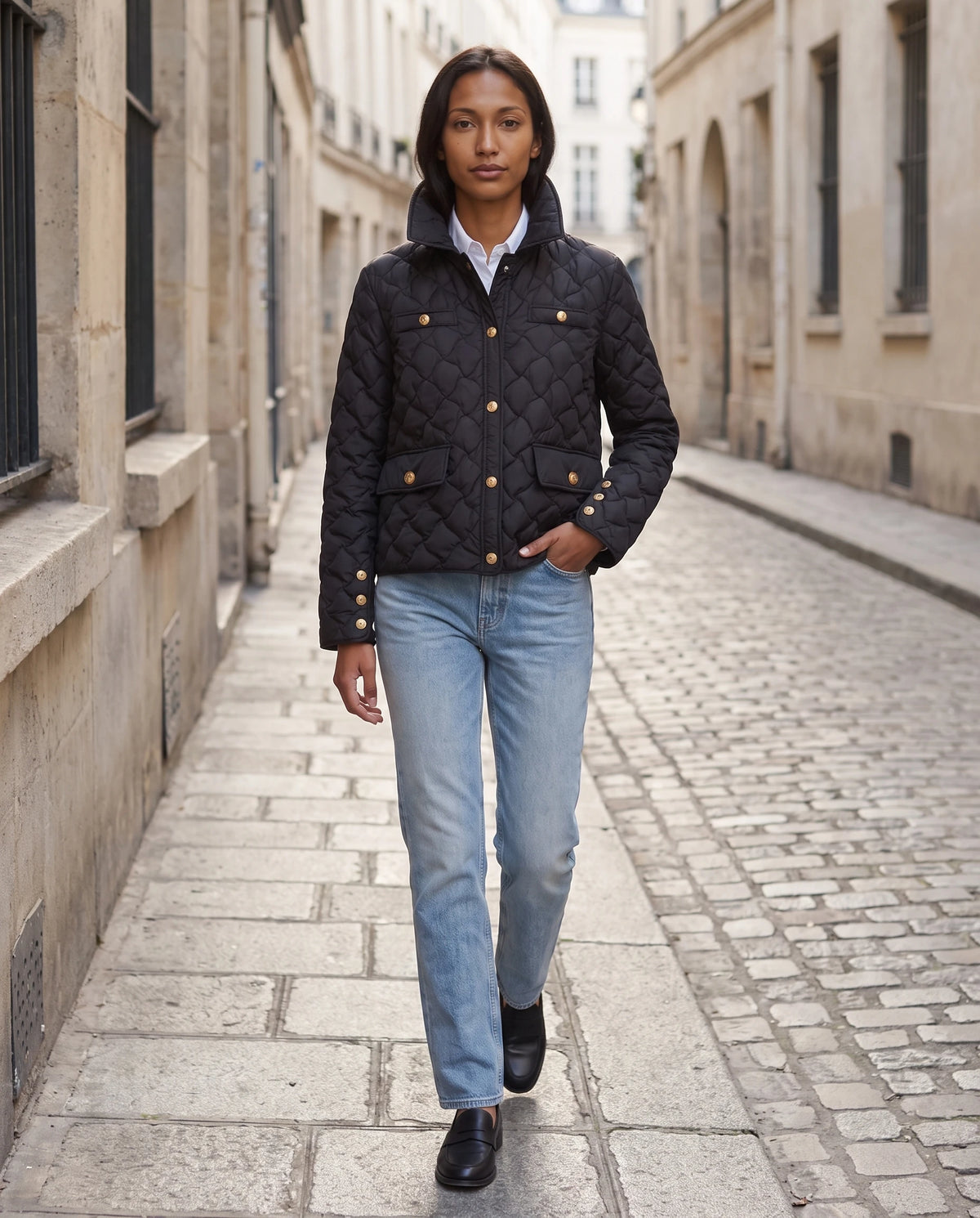 Veste matelassée à col chemise et pressions dorées Mélodie en Noir, portée dans une rue pavée au petit matin, col relevé